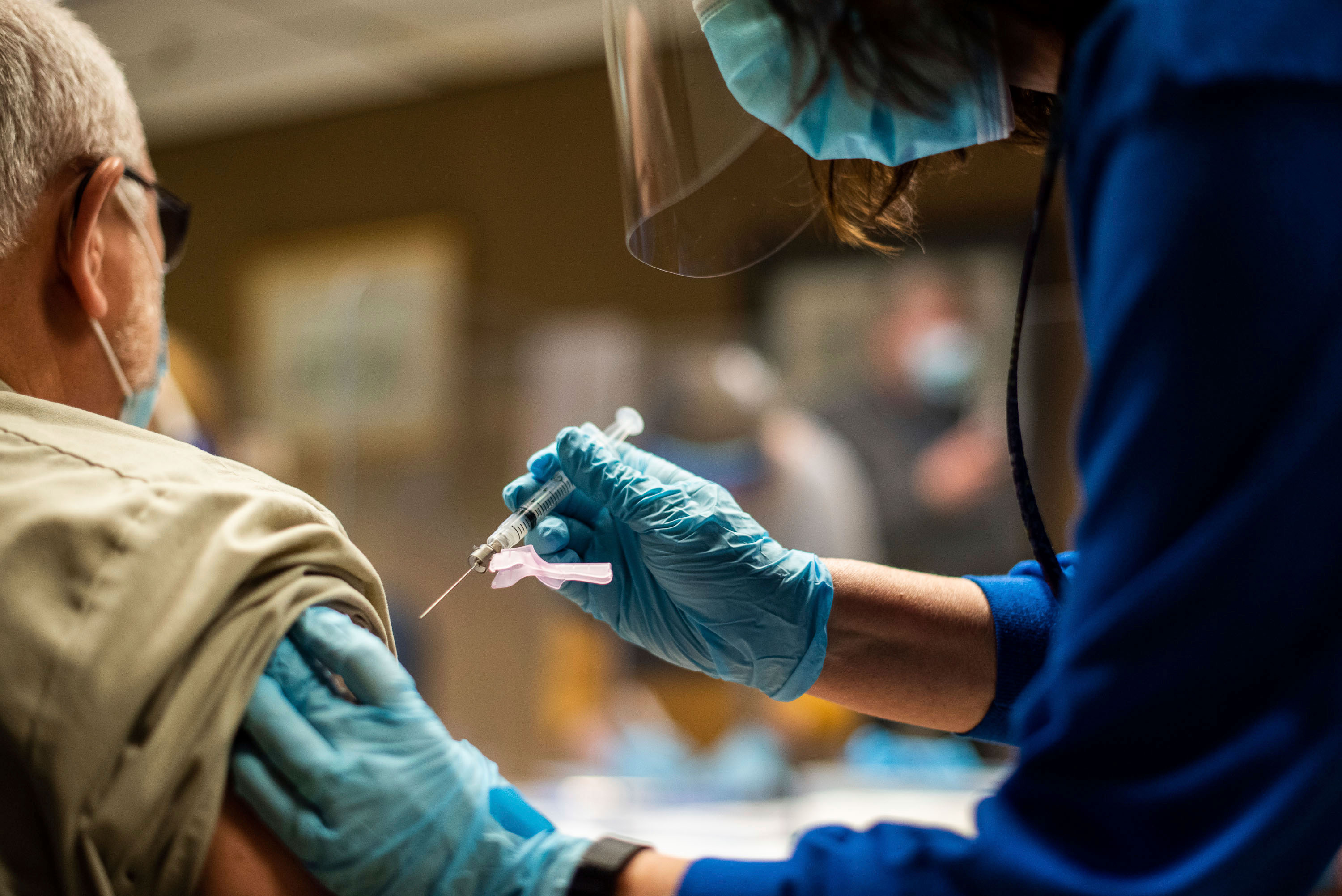 Nesta foto, tirada em 2 de fevereiro, um membro da equipe da Tyson Foods está recebendo a vacina COVID-19 de autoridades de saúde em uma instalação de Wilkesboro na Carolina do Norte.