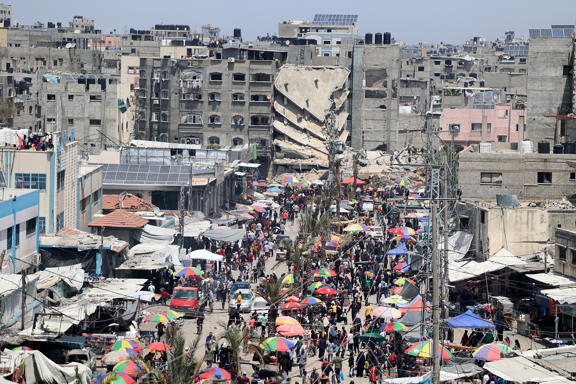 Palestinians do their daily shopping in the market set up between buildings destroyed by Israeli attacks in Beit Lahia, Gaza, on April 20.