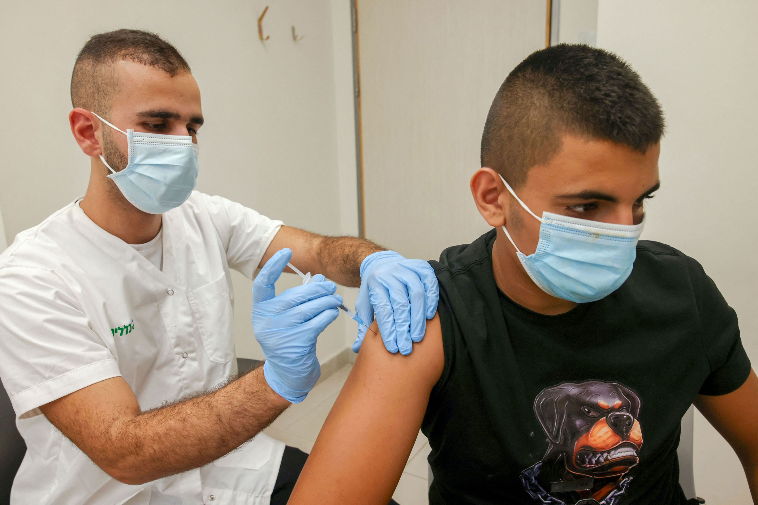 A health worker administers a dose of the Pfizer-BioNtech COVID-19 coronavirus vaccine on a man in Jerusalem on August 29, 2021