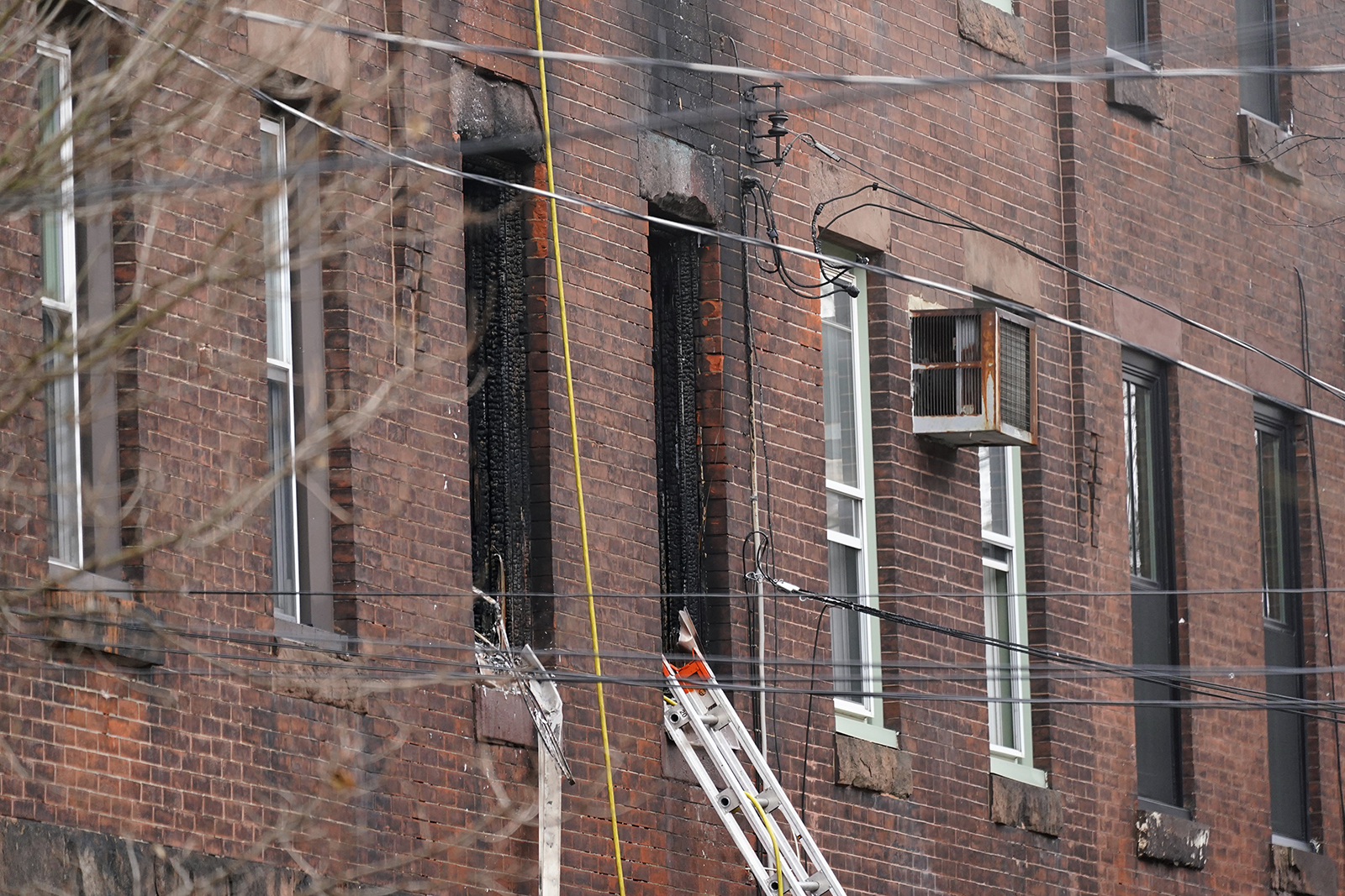 Fire damaged windows are seen at the scene of a deadly row house fire on Wednesday. 