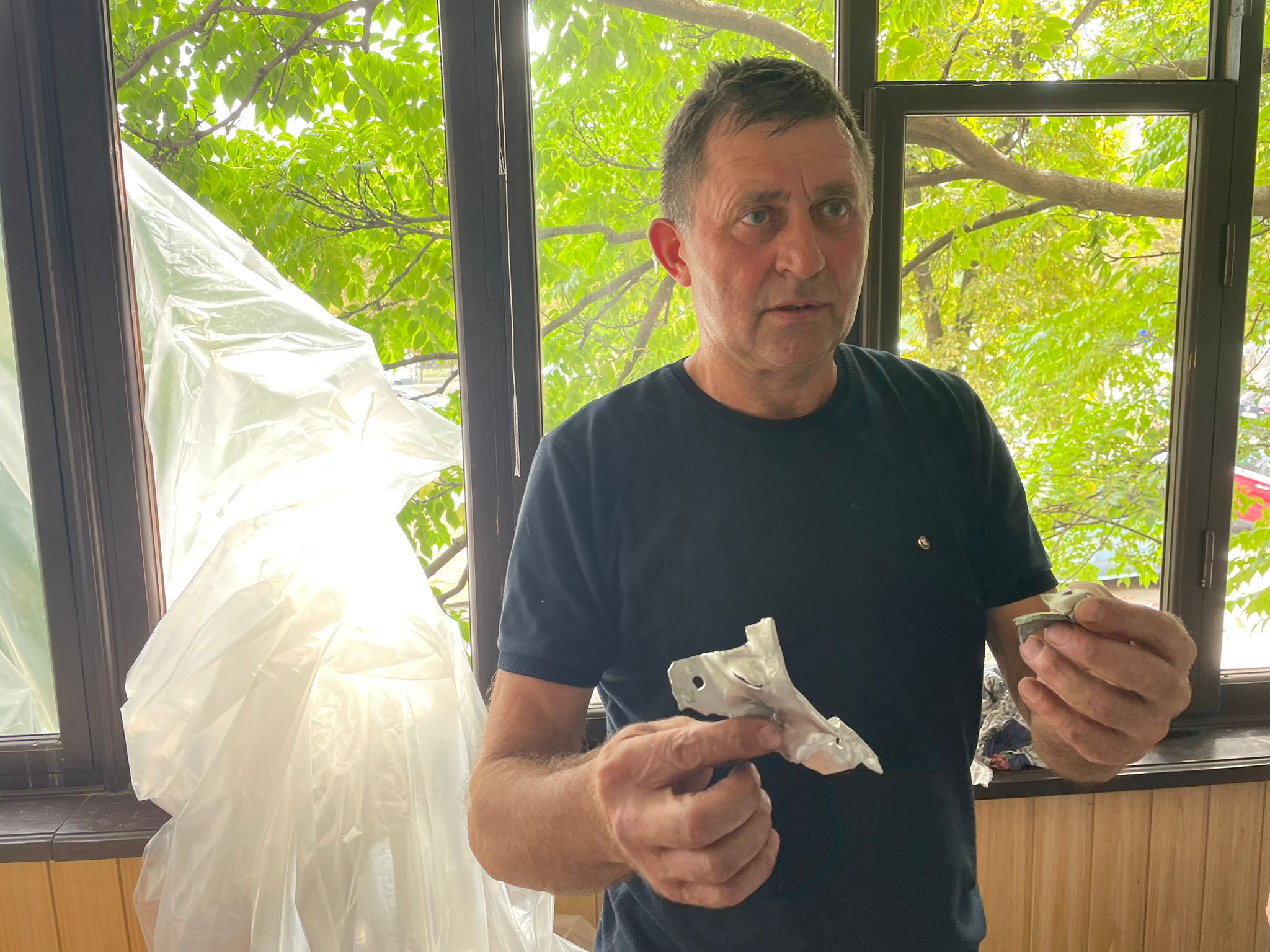 Victor Savchuk, 58 year old retiree shows bits of debris that hit his family homes balcony a residential neighborhood of Kyiv, Ukraine, on August 30.