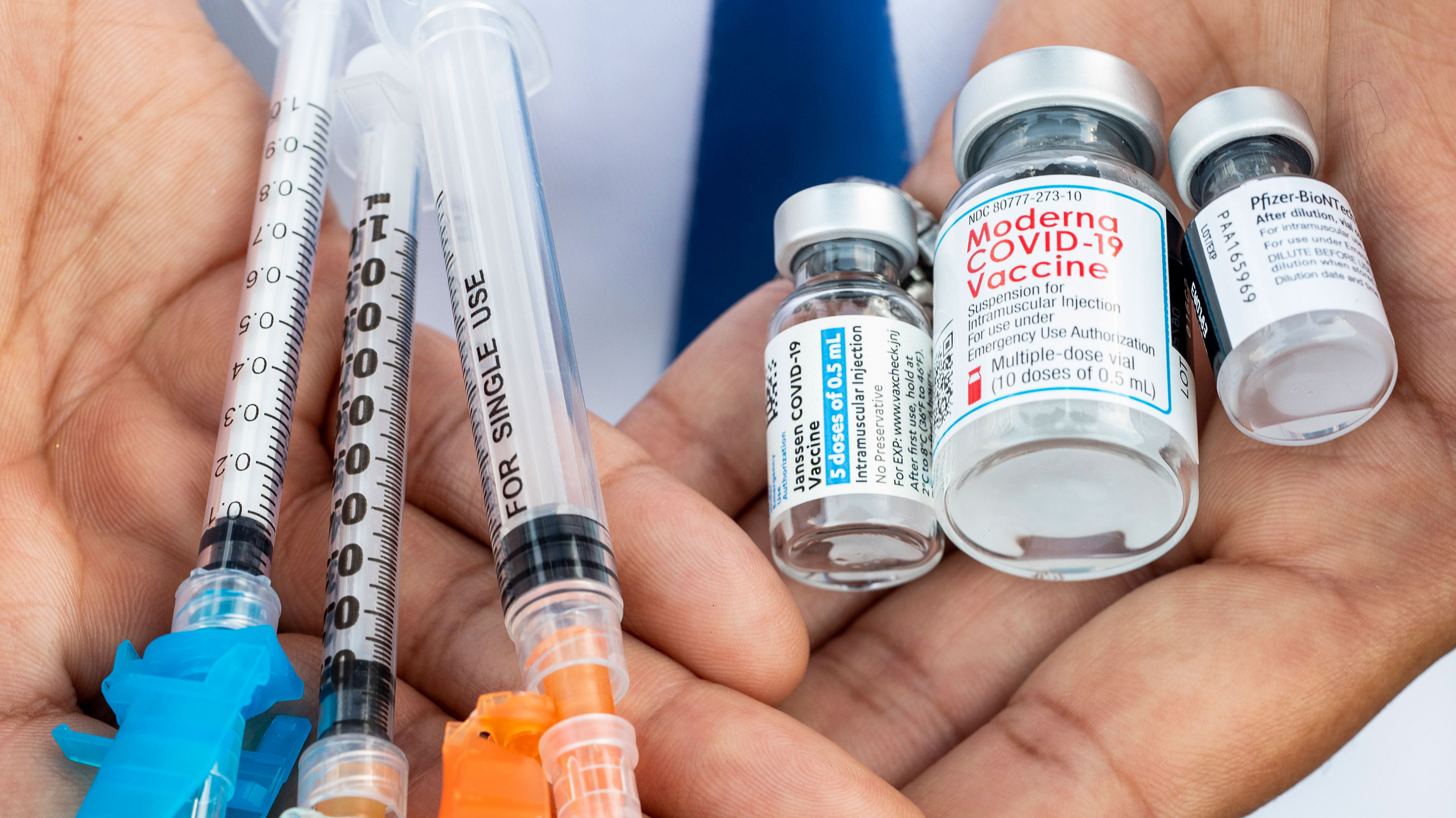 A person holds syringes and vials of the Johnson & Johnson, Moderna and Pfizer Covid-19 vaccines in Los Angeles in May.