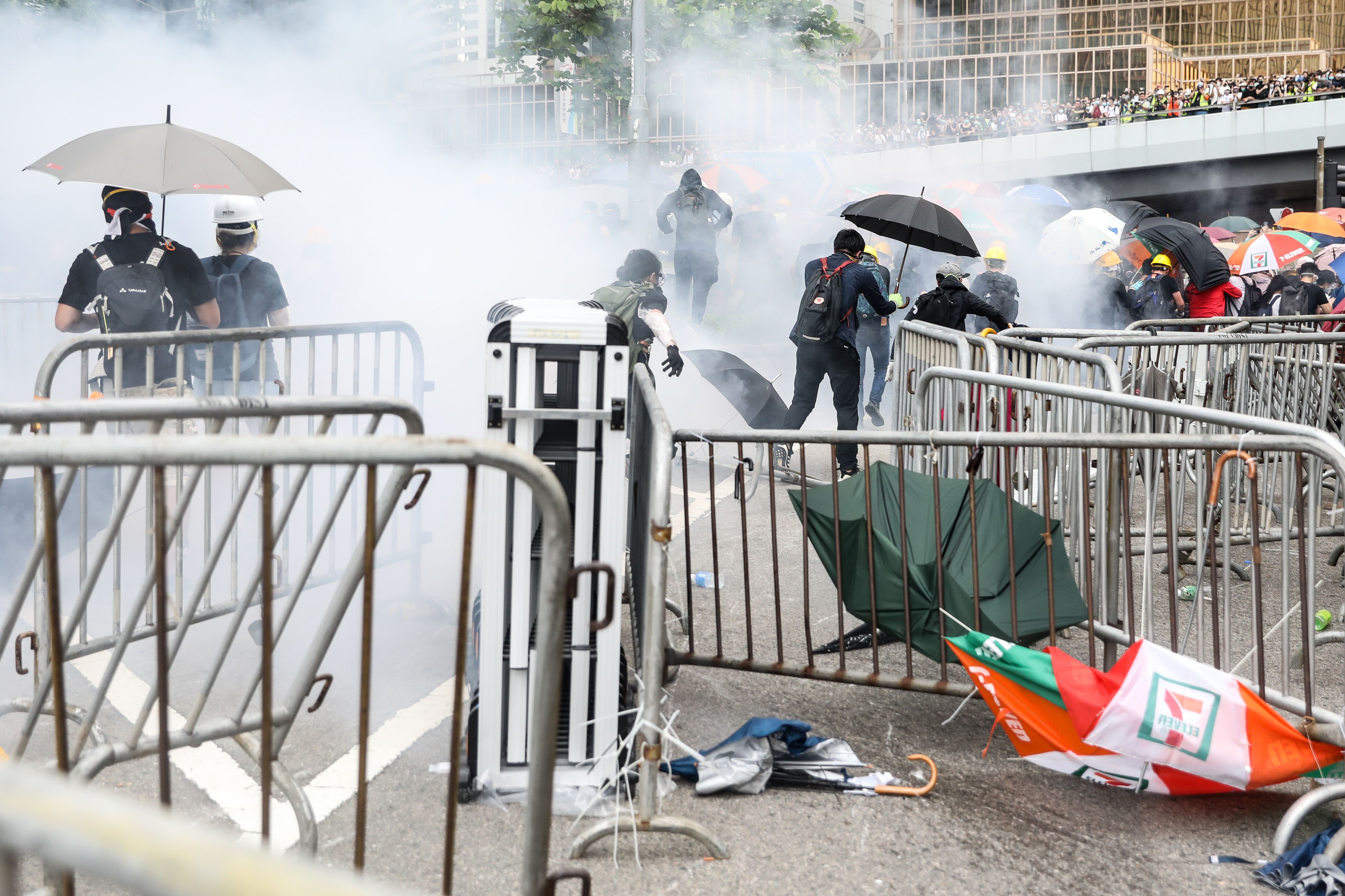 Protesters retreat after police fired tear gas during a rally against a controversial extradition law proposal outside the government headquarters in Hong Kong on June 12,
