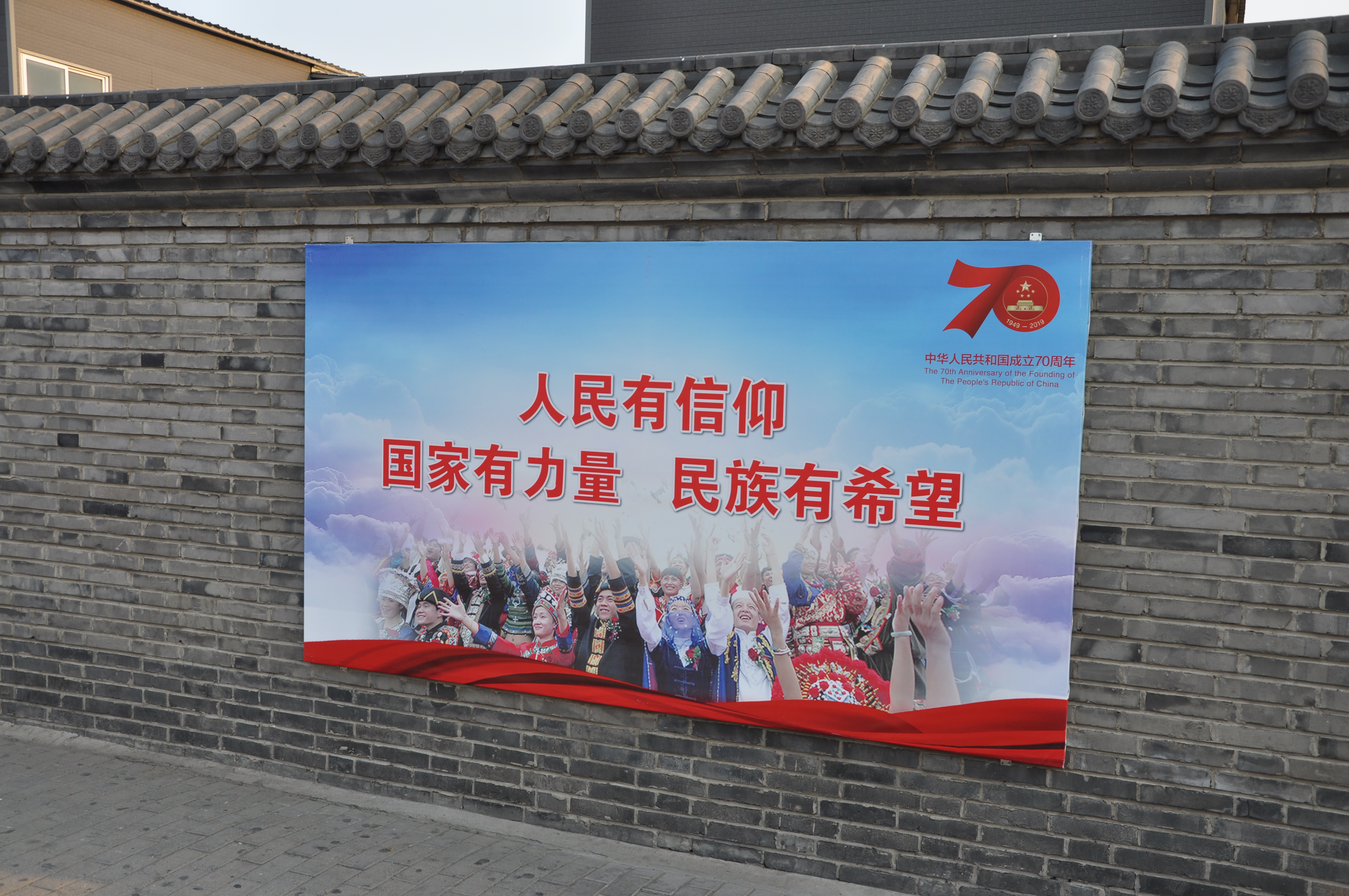 A propaganda poster on the wall of a building near the Forbidden City.