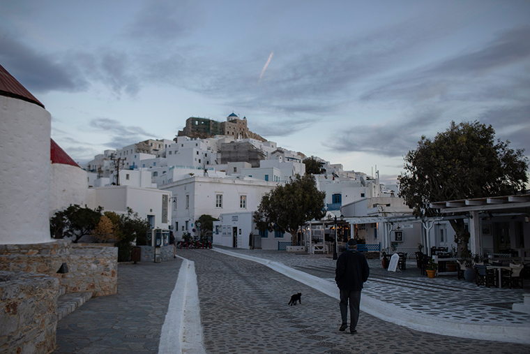A man walks along a quiet street on the island of Astypalea, Greece on Monday, Nov. 2, 2020. 