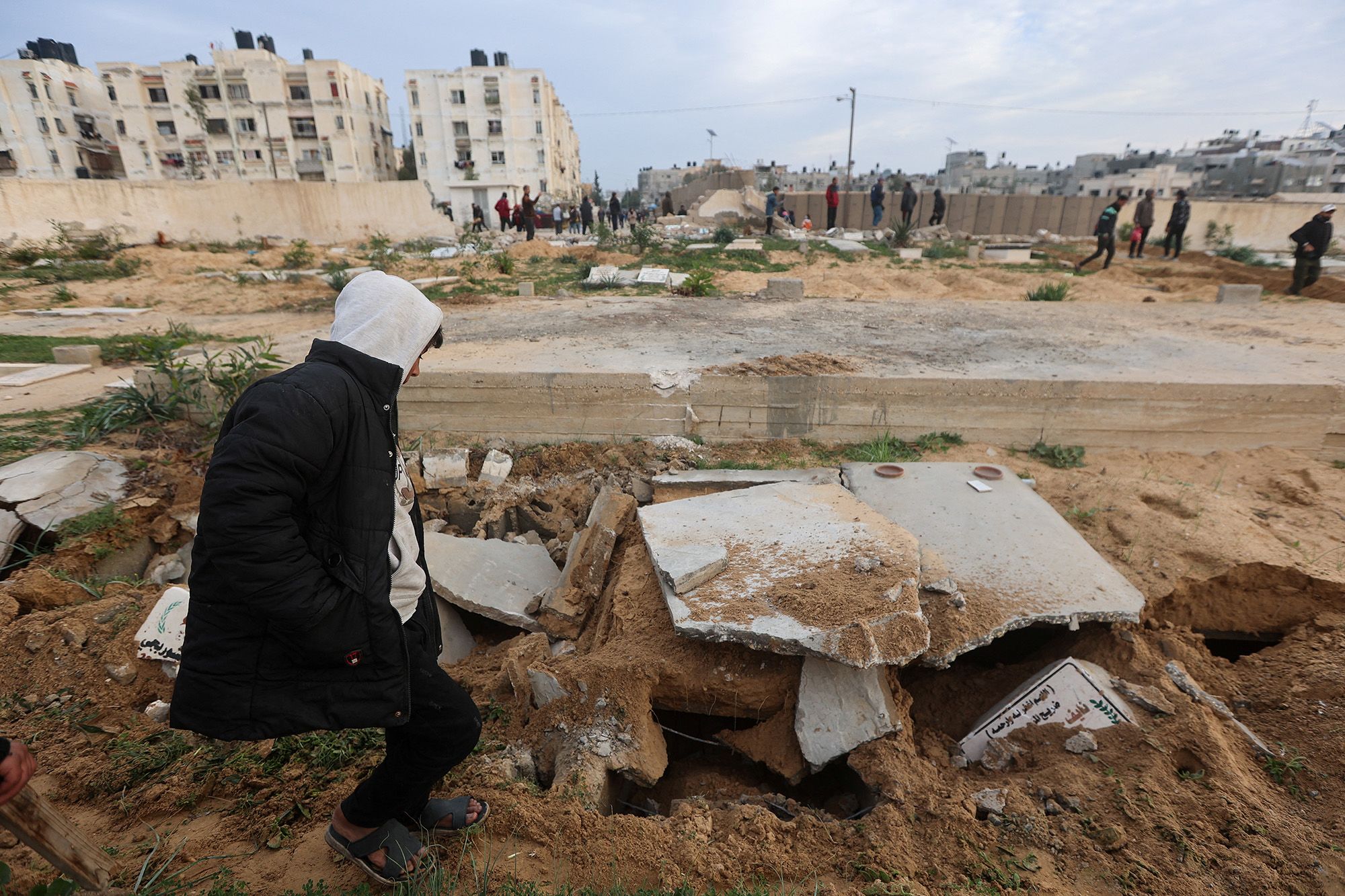 Palestinians check damaged graves at a cemetery following an Israeli raid in Khan Younis, Gaza, on January 17.