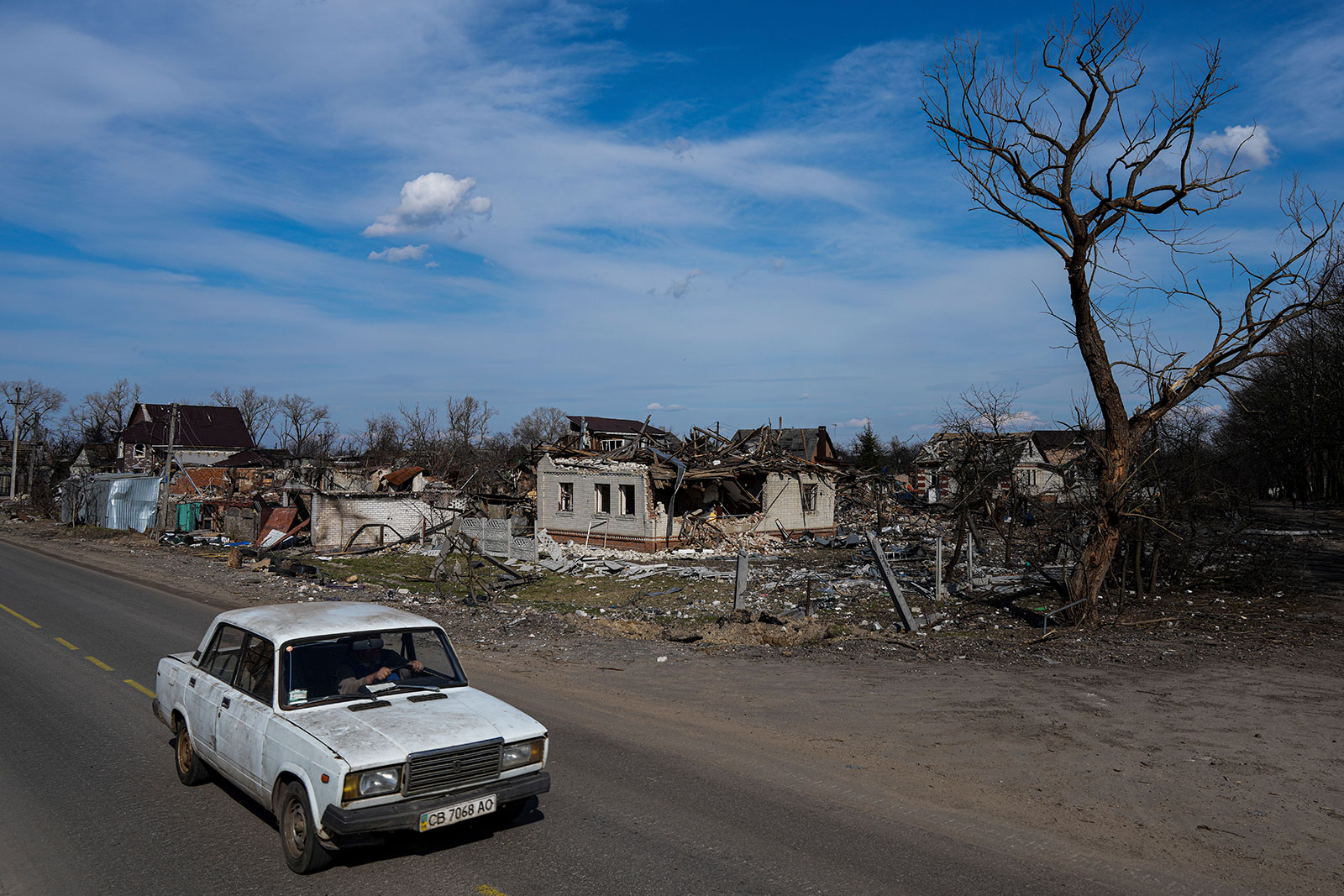 A car moves in a street past damaged houses in Chernihiv, Ukraine, on Thursday, April 7. 