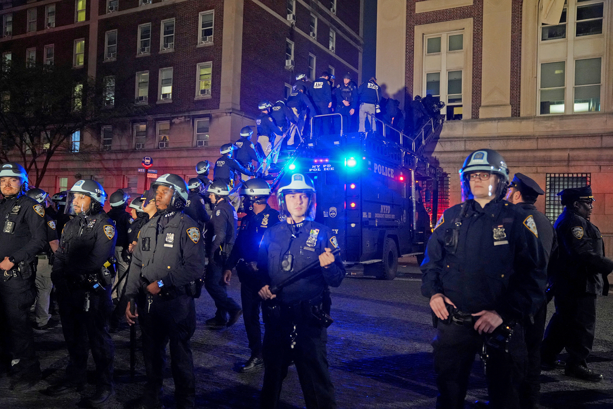 Die Polizei nutzt ein Spezialfahrzeug, um am 30. April in die von Demonstranten besetzte Hamilton Hall einzudringen, während andere Beamte den Campus der Columbia University in New York City betreten.