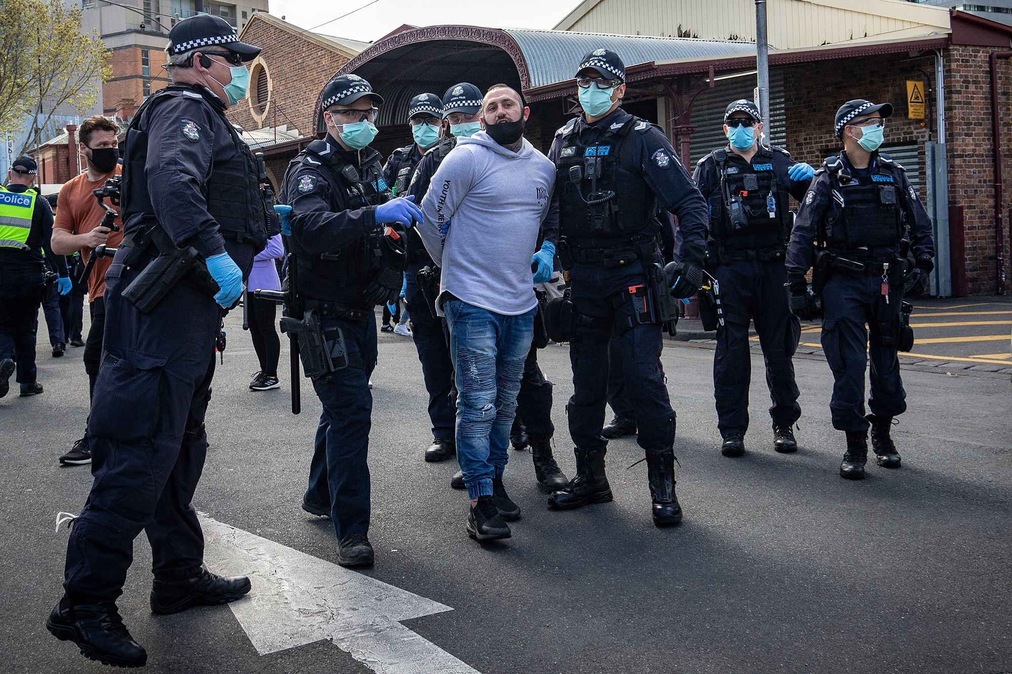 A man is detained by police on Sunday in Melbourne after anti-lockdown protesters organized a 