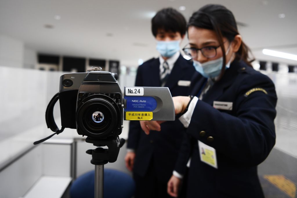 Airport employees set up an advanced thermal imaging camera to screen passengers at Narita airport in Tokyo on January 23.