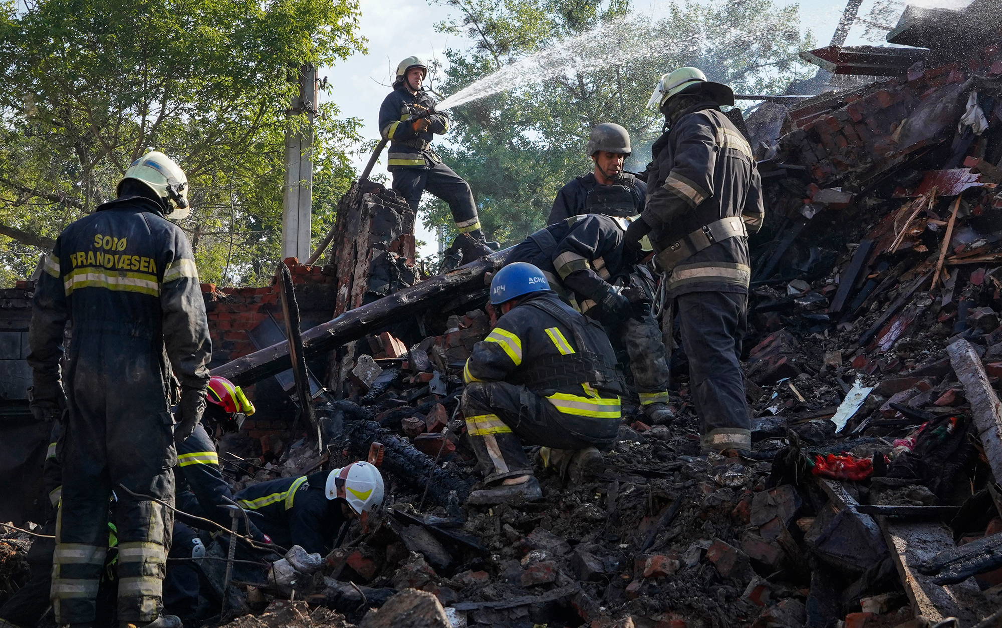 Firefighters dig through the rubble of a building destroyed during a missile strike in Kharkiv, Ukraine, on Thursday, August 18. 