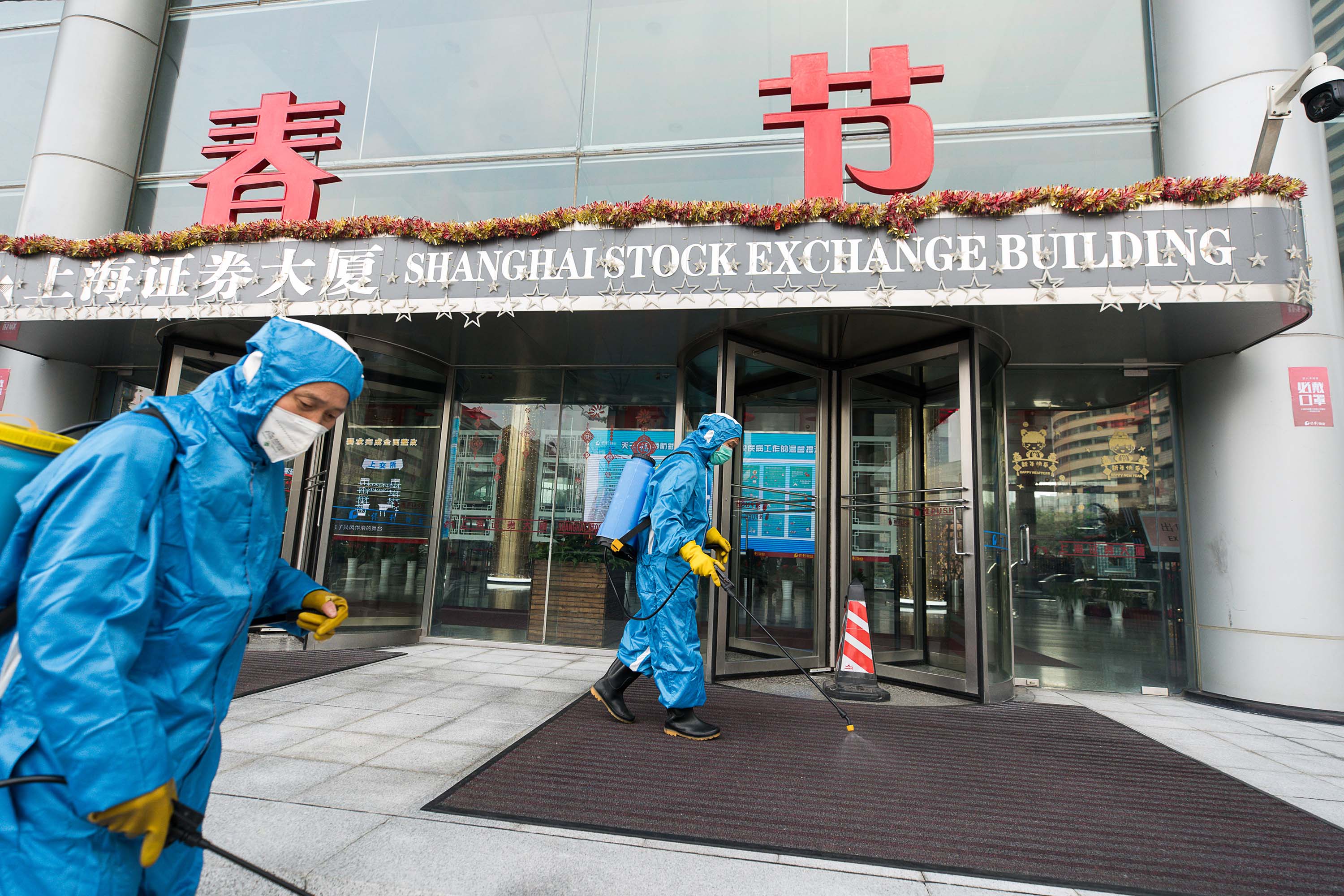 Medical workers spray antiseptic outside of the Shanghai Stock Exchange Building on Monday.