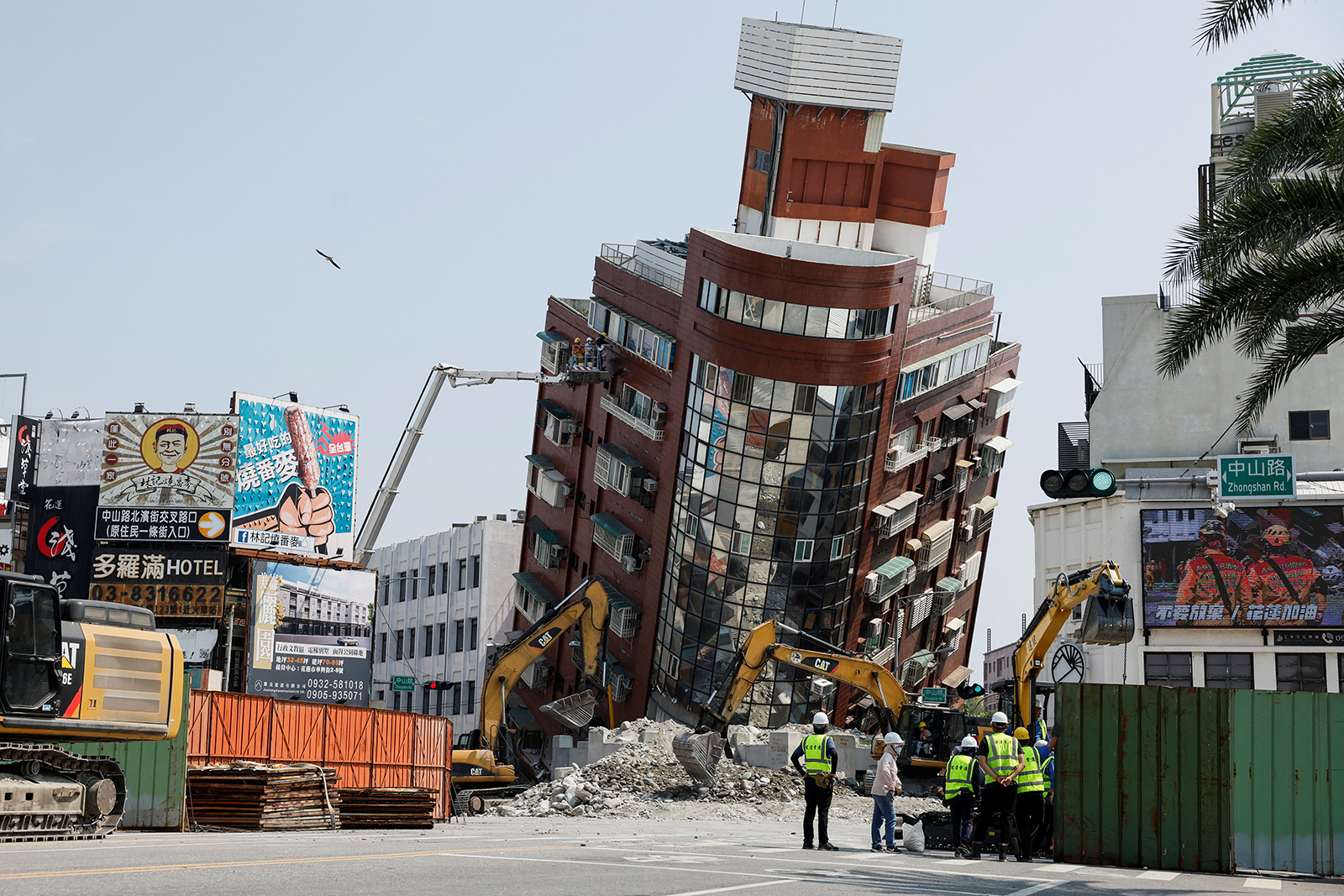 A partially collapsed building stands at a titled angle as workers carry out operations a day after a powerful earthquake struck in Hualien City, eastern Taiwan, on April 4.