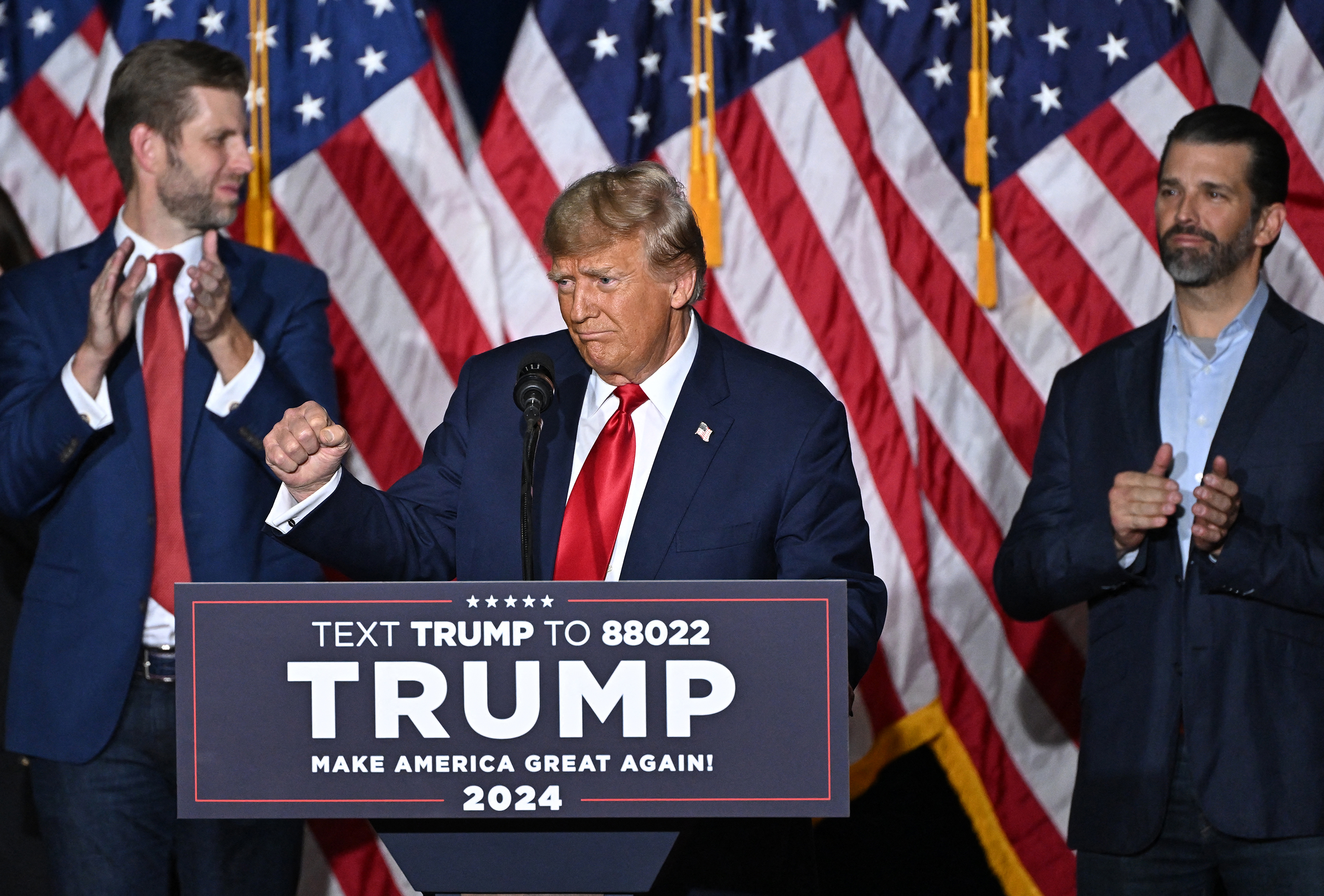 Former US President and Republican presidential candidate Donald Trump, with sons Eric (L) and Donald (R), speaks at a watch party during the 2024 Iowa Republican presidential caucuses in Des Moines, Iowa, on January 15.