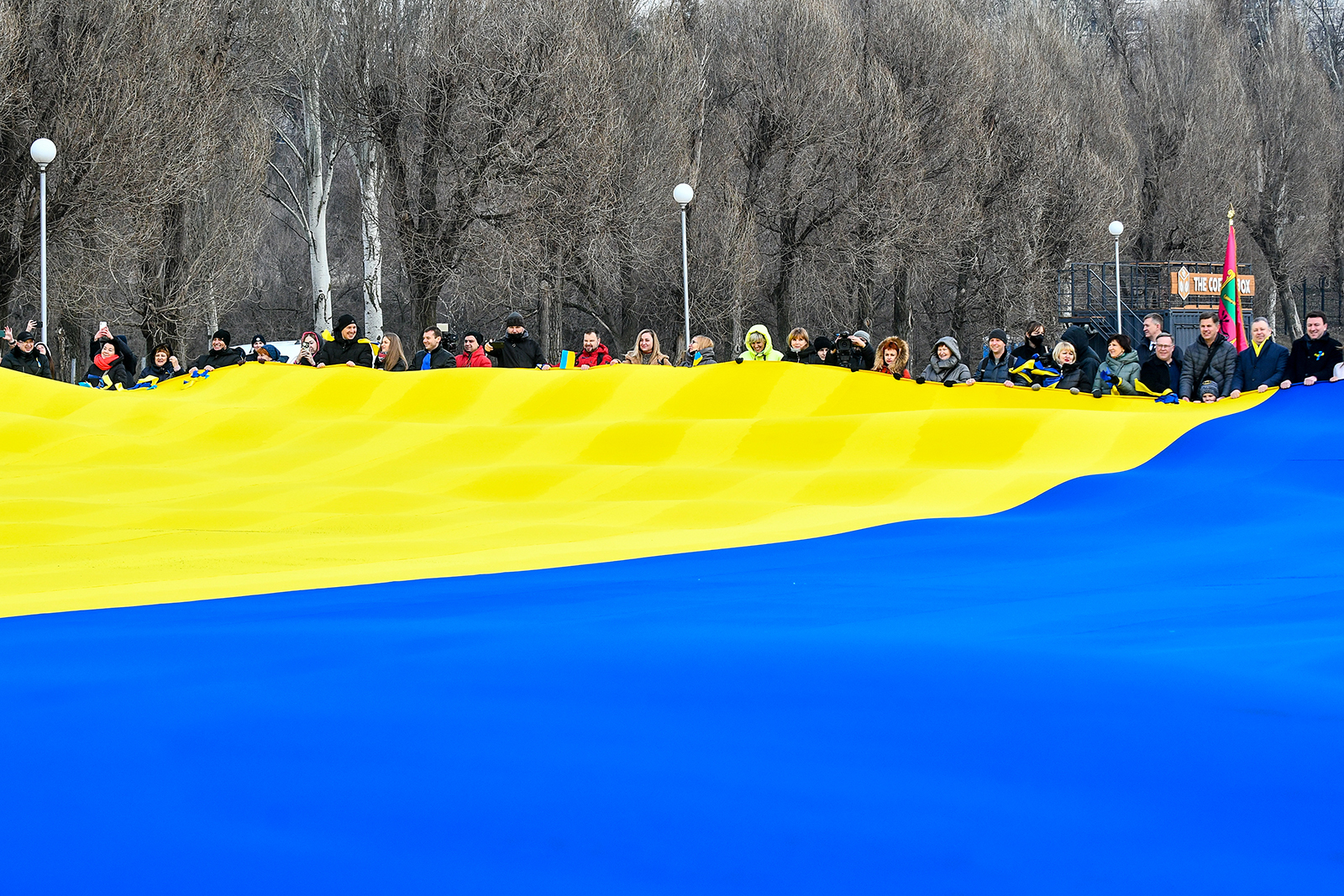People hold the State Flag of Ukraine measuring 50 by 20 metres at the Raduha (Rainbow) cascade of fountains on the Day of Unity, Zaporizhzhia, southeastern Ukraine on February 16.