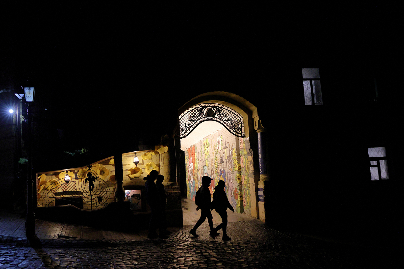 People walk on a dark street in the old town of Kyiv, Ukraine, on November 6.