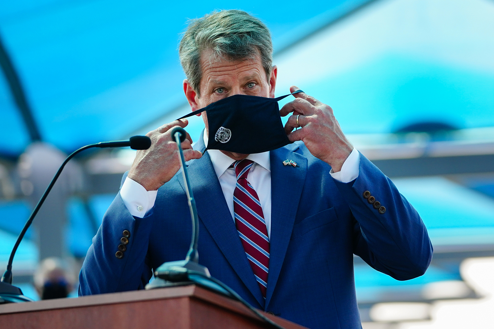 Georgia Gov. Brian Kemp puts on a mask after speaking at a press conference announcing statewide expanded Covid-19 testing on August 10 in Atlanta, Georgia. 