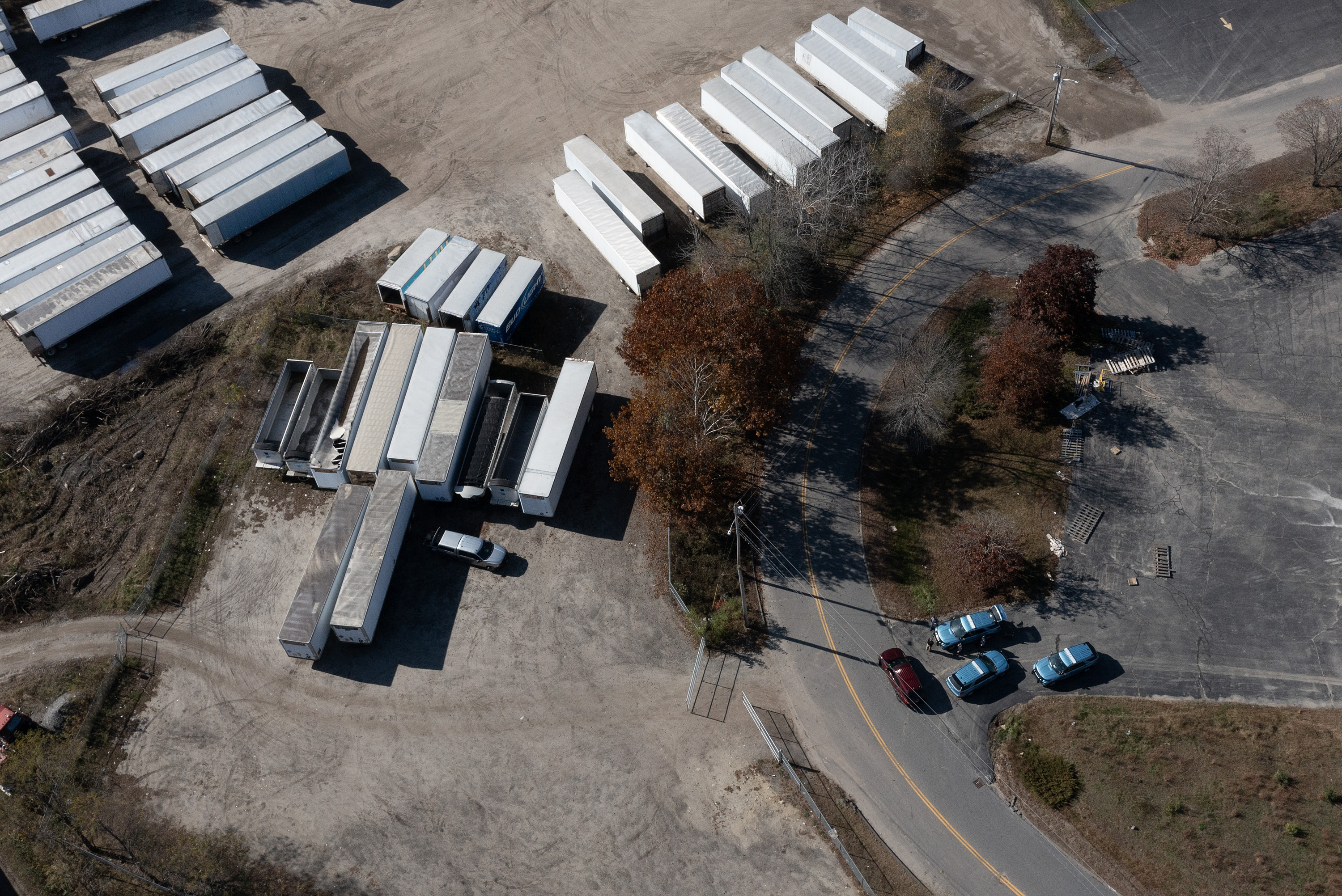 In an aerial view, law enforcement officials are seen investigating the area where Robert Card, the suspect in two mass killings, was found dead on October 28 in Lisbon, Maine.