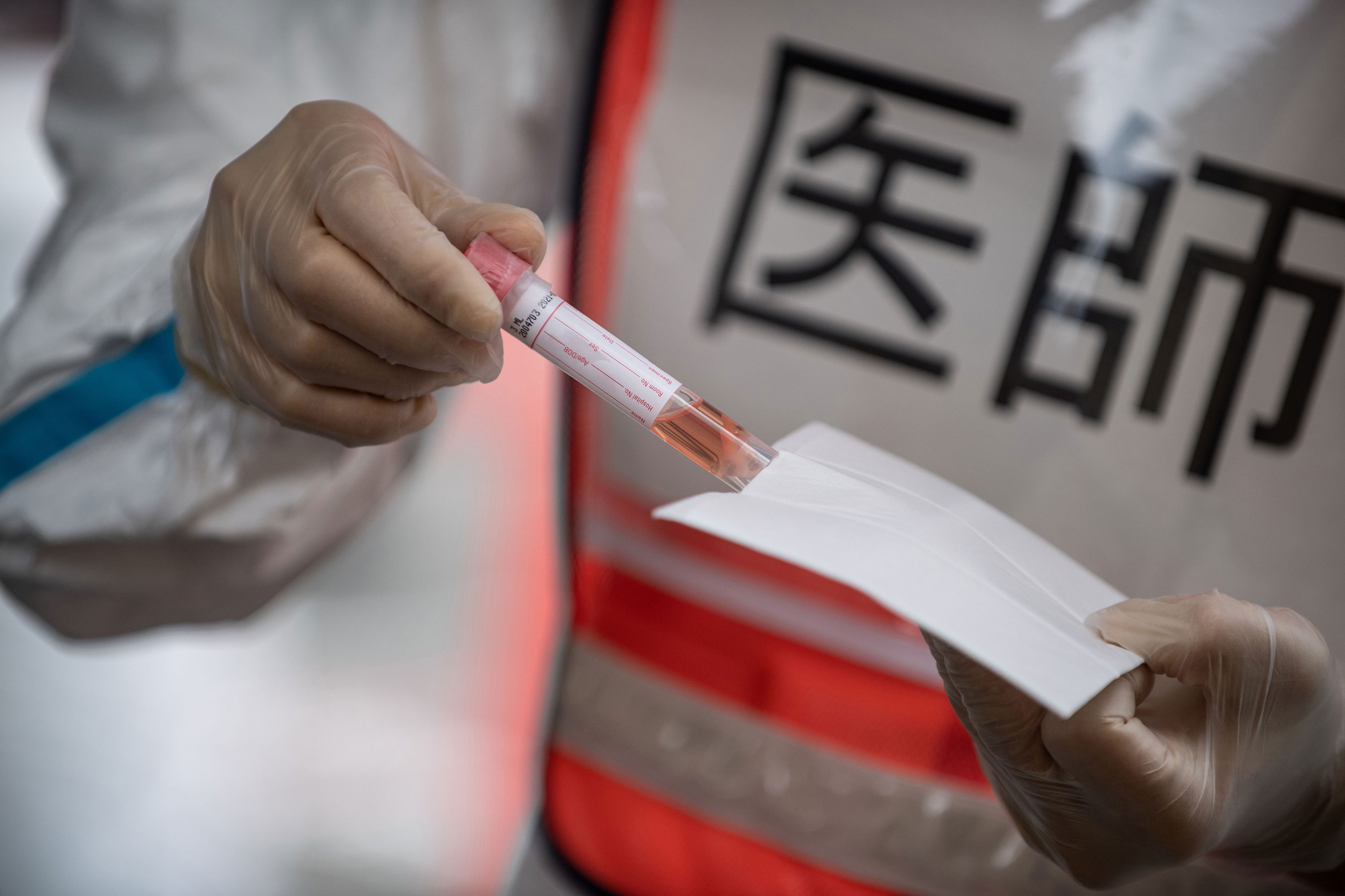 A doctor holds a coronavirus test sample at a drive-thru testing site in Fujisawa, Japan, on April 27.