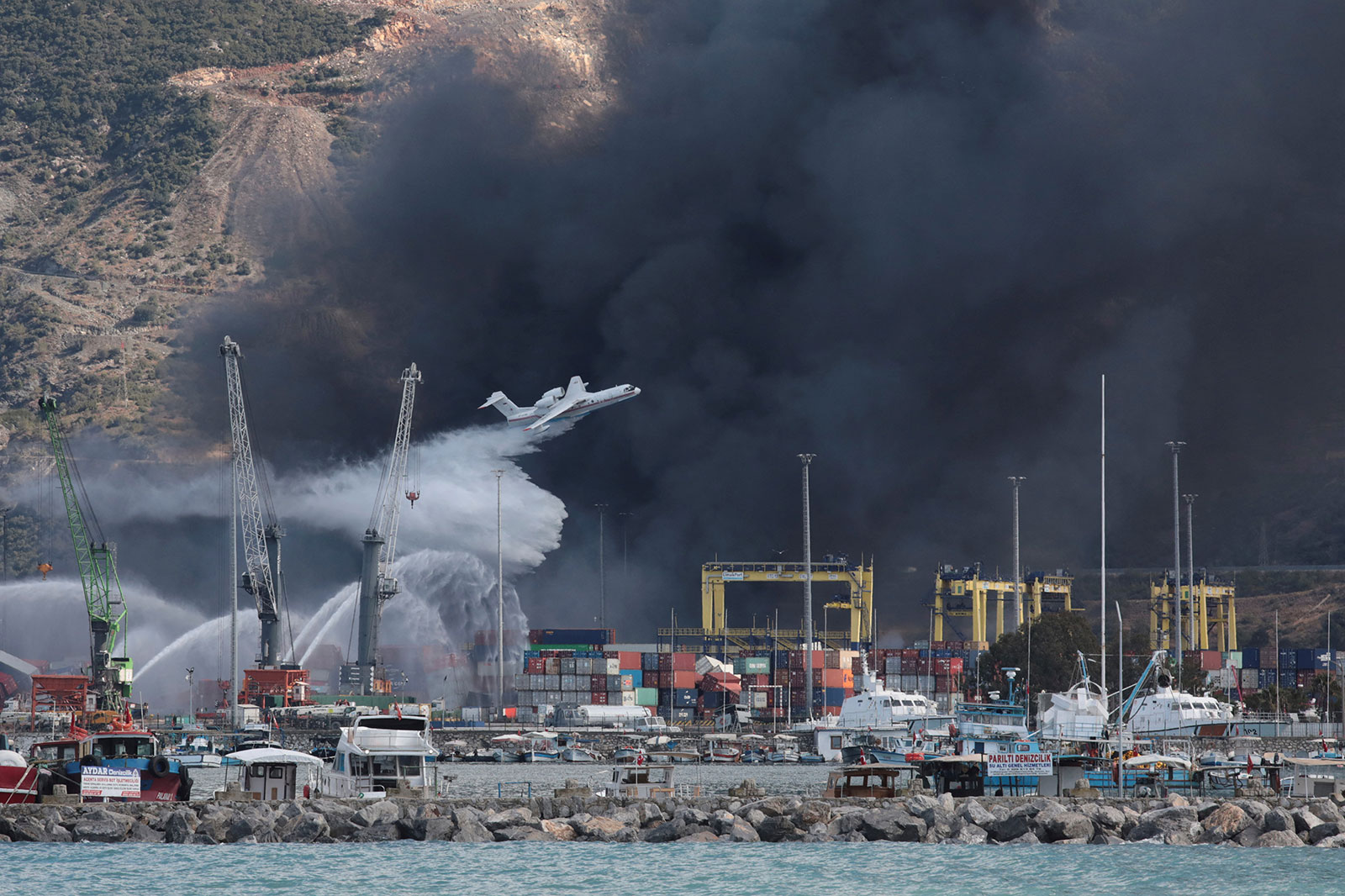 A plane drops water over the the Iskenderun port in the aftermath of an earthquake on Wednesday. 