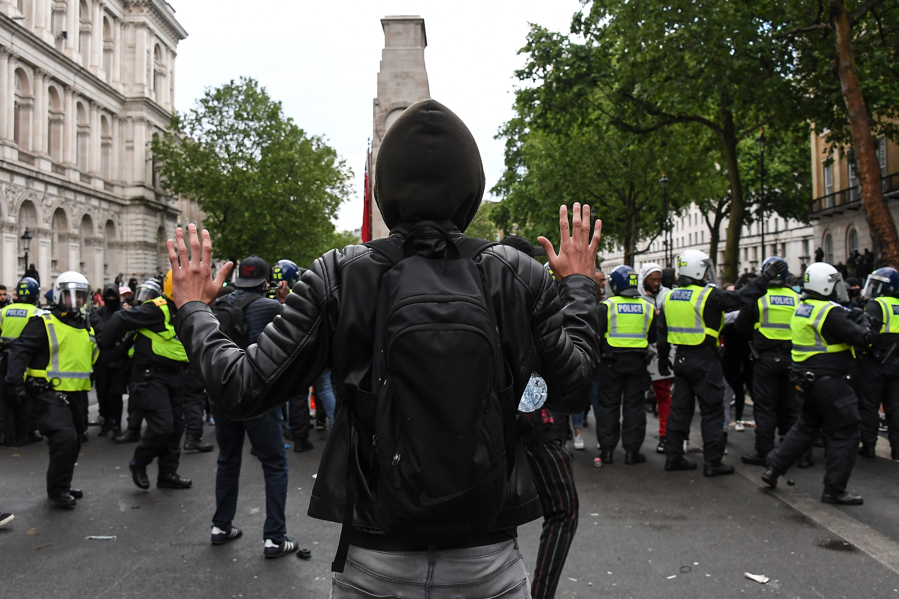 A man raises his hands as police scuffle with demonstrators in London on June 6.