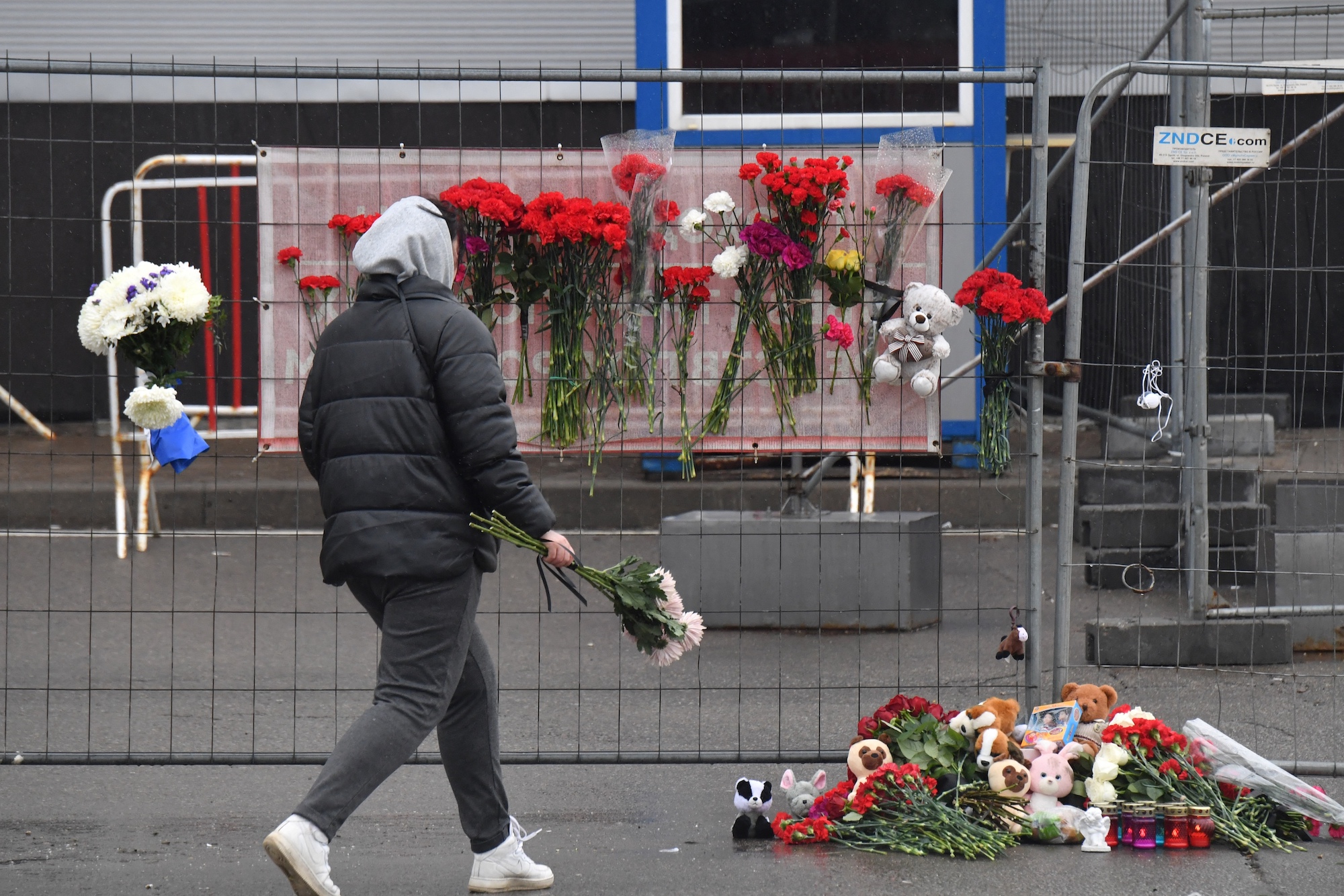 A woman lays flowers at a makeshift memorial in front of the Crocus City Hall in Krasnogorsk, outside Moscow, on Saturday.