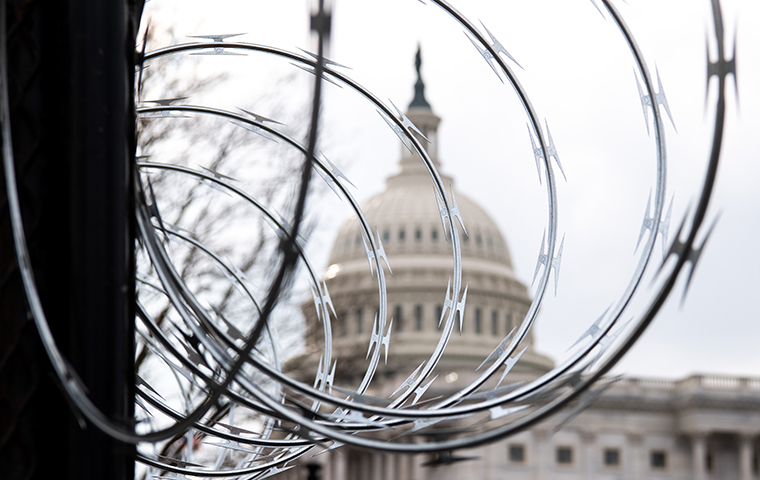 Barbed wire is installed atop a security fence surrounding the U.S. Capitol in Washington, DC on Friday, January 15.