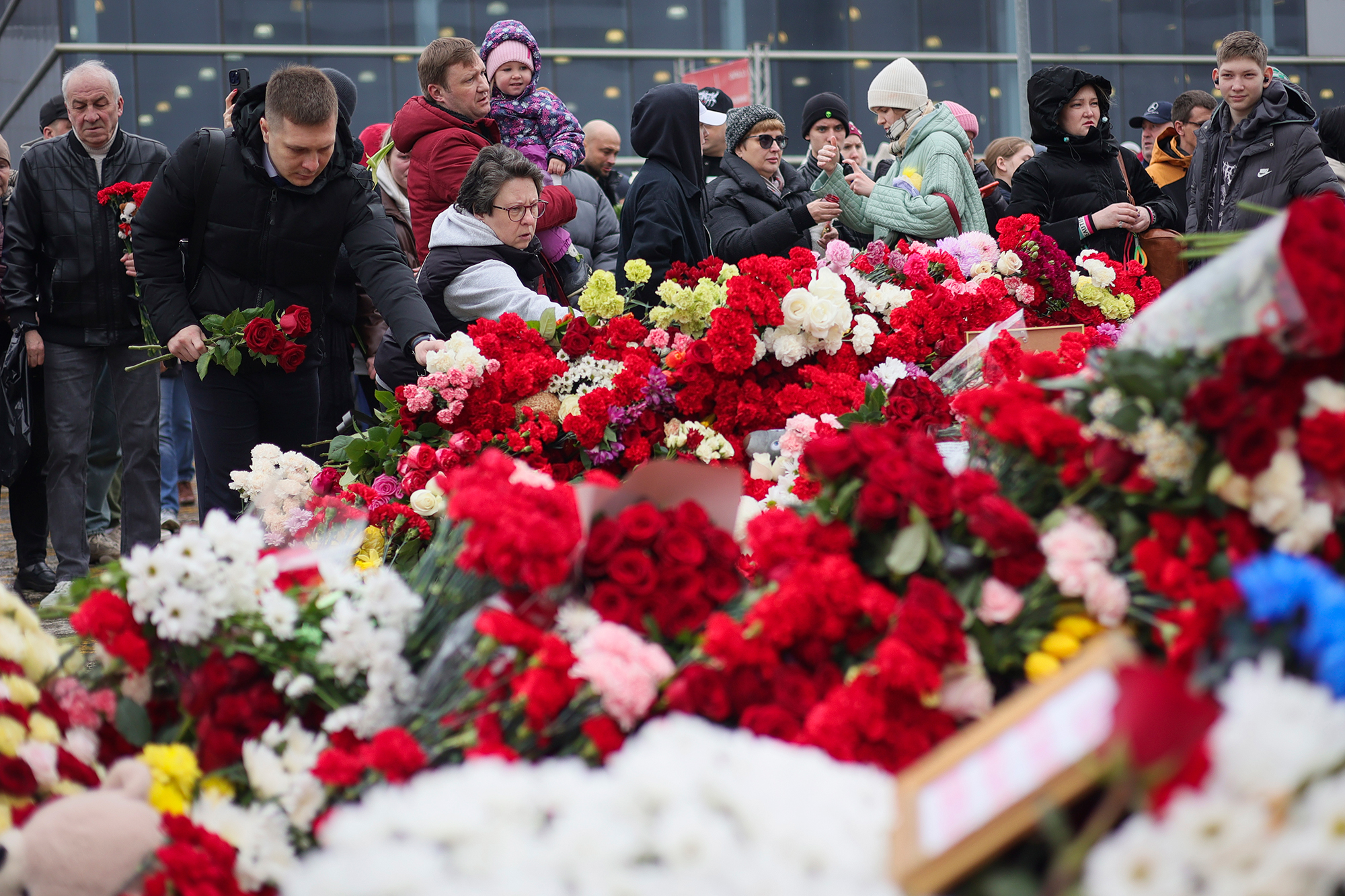 People place flowers at a memorial outside Crocus City Hall in Moscow on Sunday. 