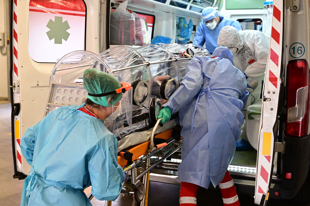 Medical staff transfer a COVID-19 patient in a bio-containment stretcher from the Garbagnate Milanaise hospital to Varese hospital on October 19, in Italy.