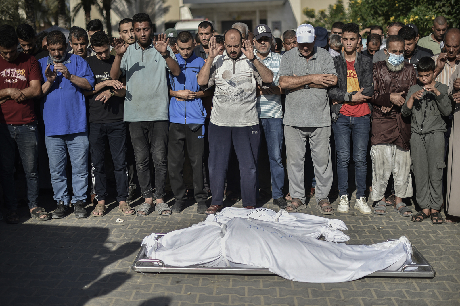 People perform funeral prayers next to the bodies of Palestinians killed in Israeli airstrikes, at a cemetery in Khan Younis, Gaza on October 26.