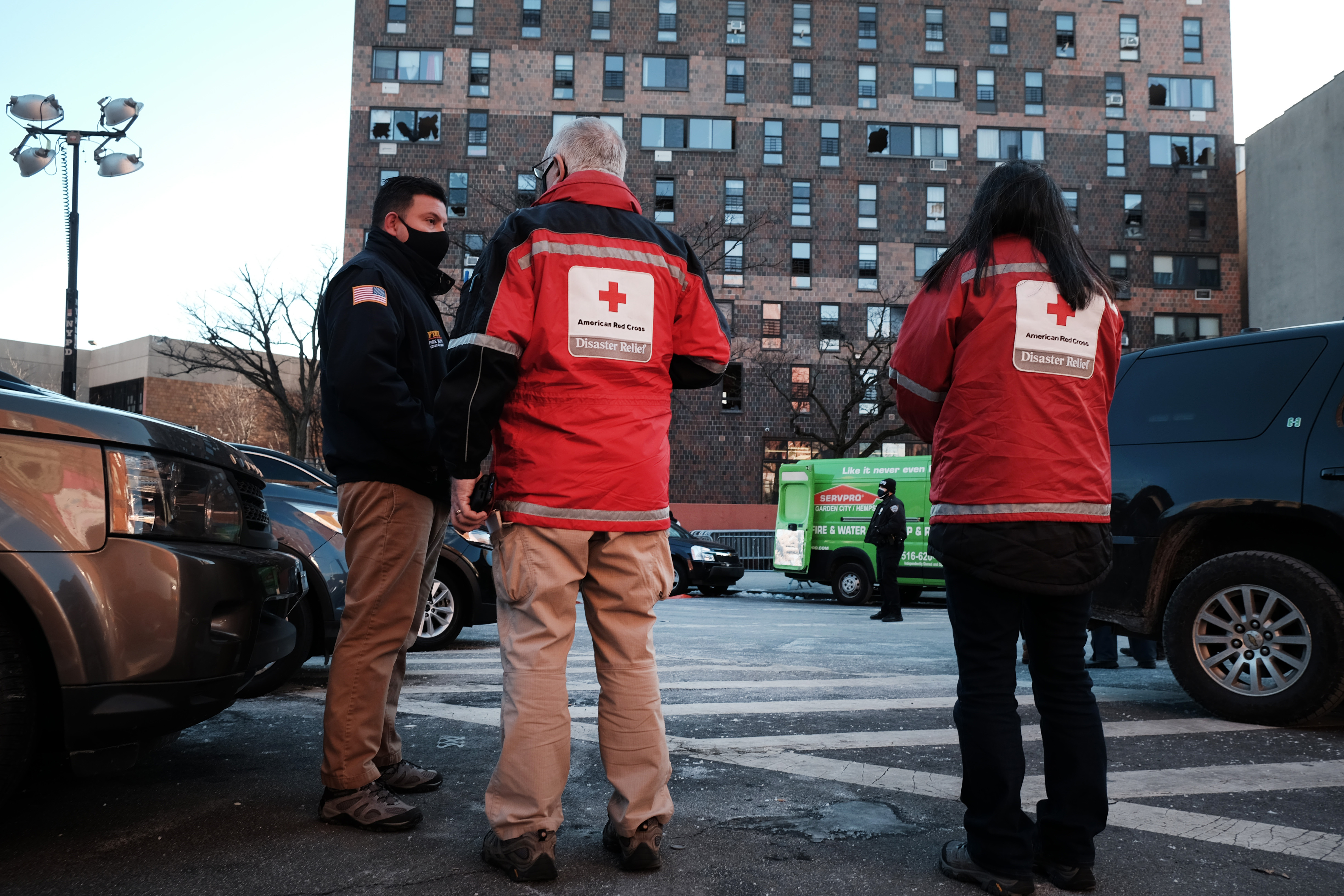 Members of the Red Cross stand in front of a Bronx apartment building a day after a deadly fire swept through. 