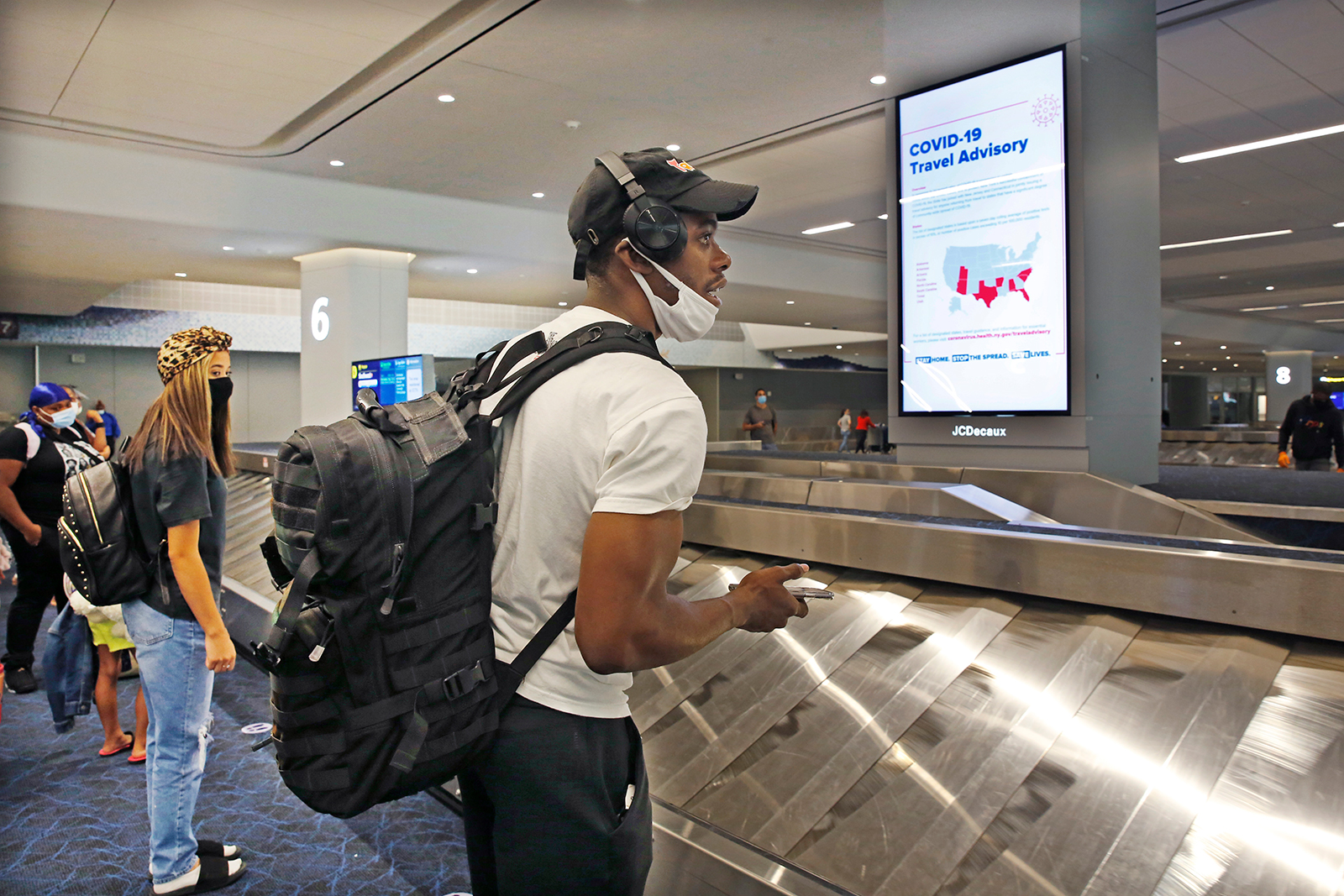 Arriving passengers wait for their bags in the baggage claim area at LaGuardia Airport's Terminal B baggage claim area, on Thursday, June 25, in New York City.