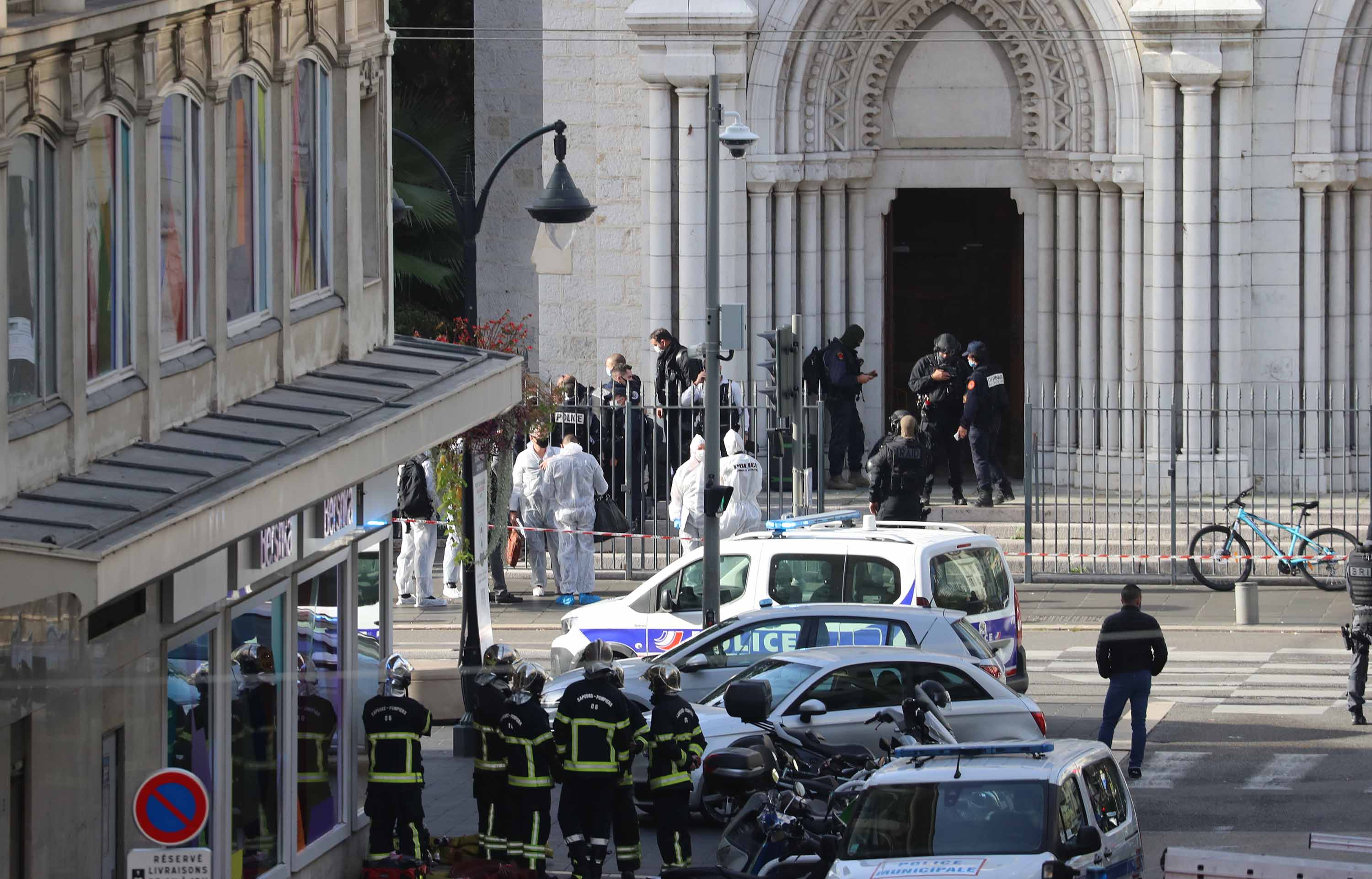 French authorities enter to search the Basilica of Notre-Dame de Nice as forensics officers wait outside on Thursday.