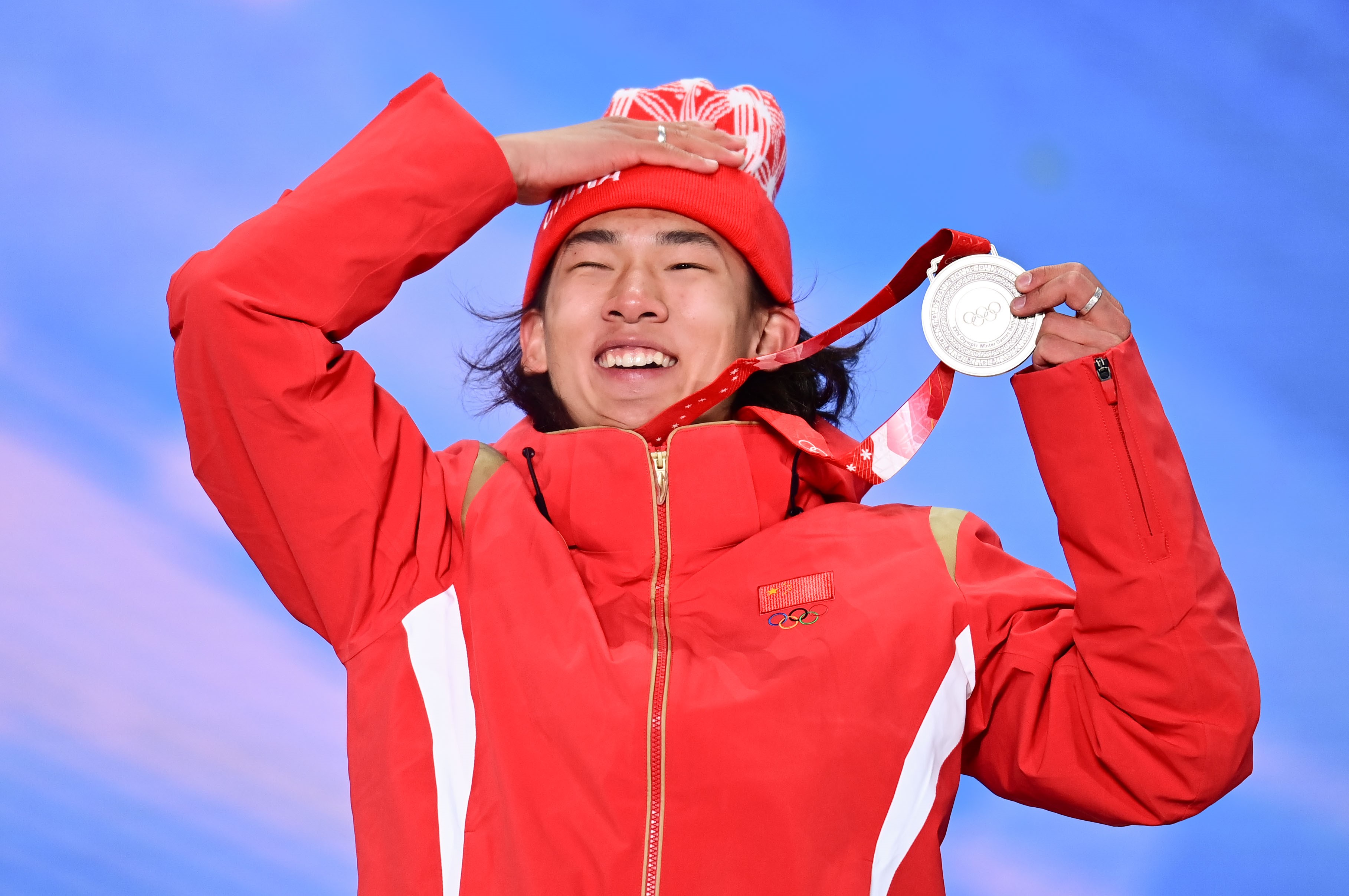 Su Yiming holds up his silver medal for men's snowboard slopestyle on Feb. 7.
