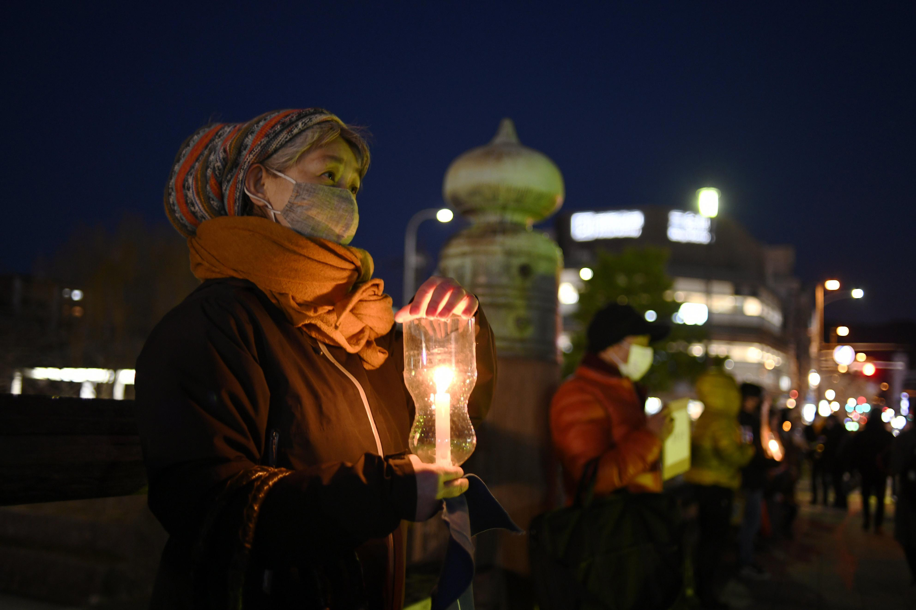 People hold candles during a protest in support of Ukraine on February 27, in Kyoto, Japan. 
