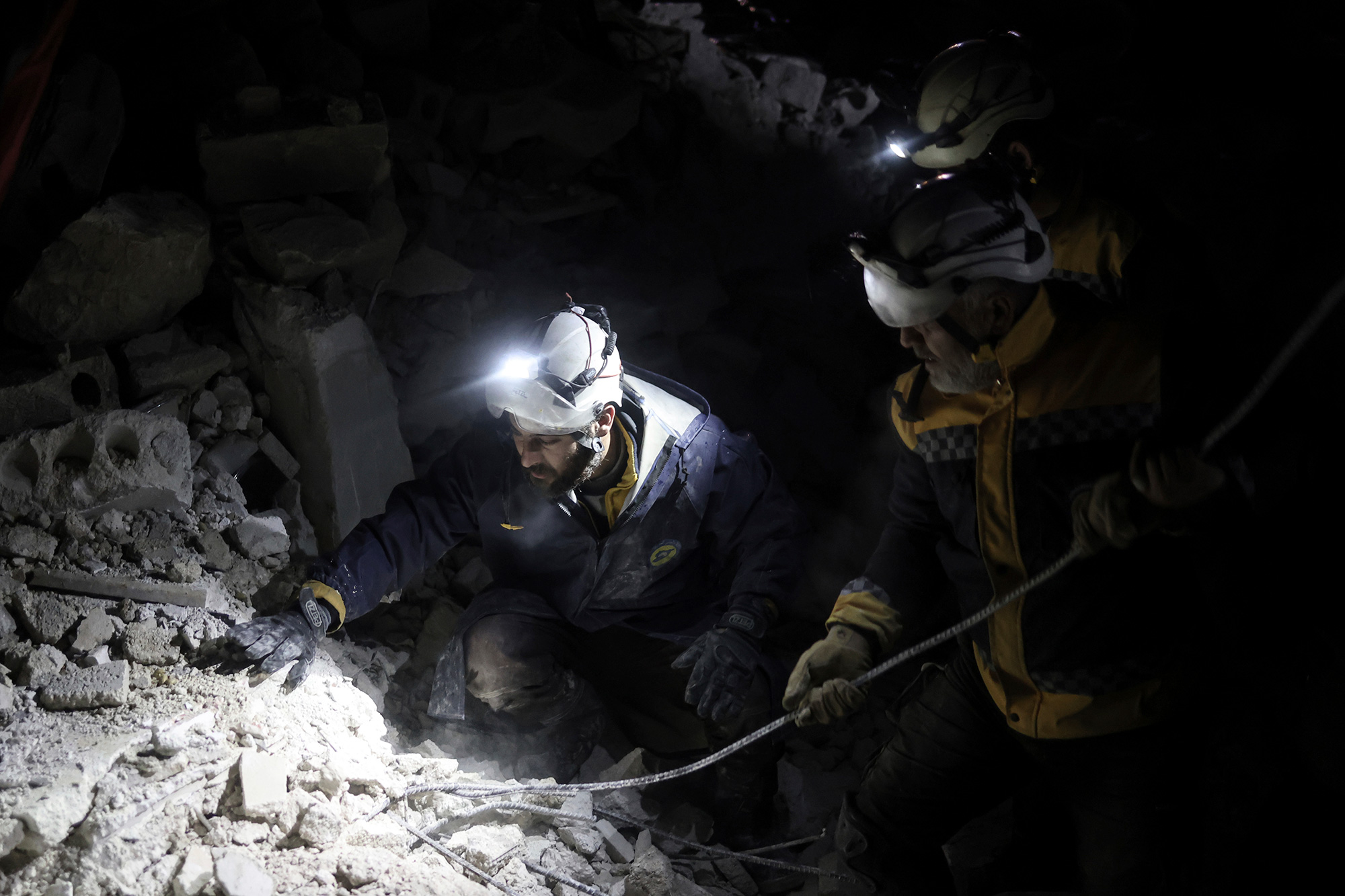 Civilians and White Helmets members work to save people trapped beneath a destroyed building in Harem, Syria, on February 7.