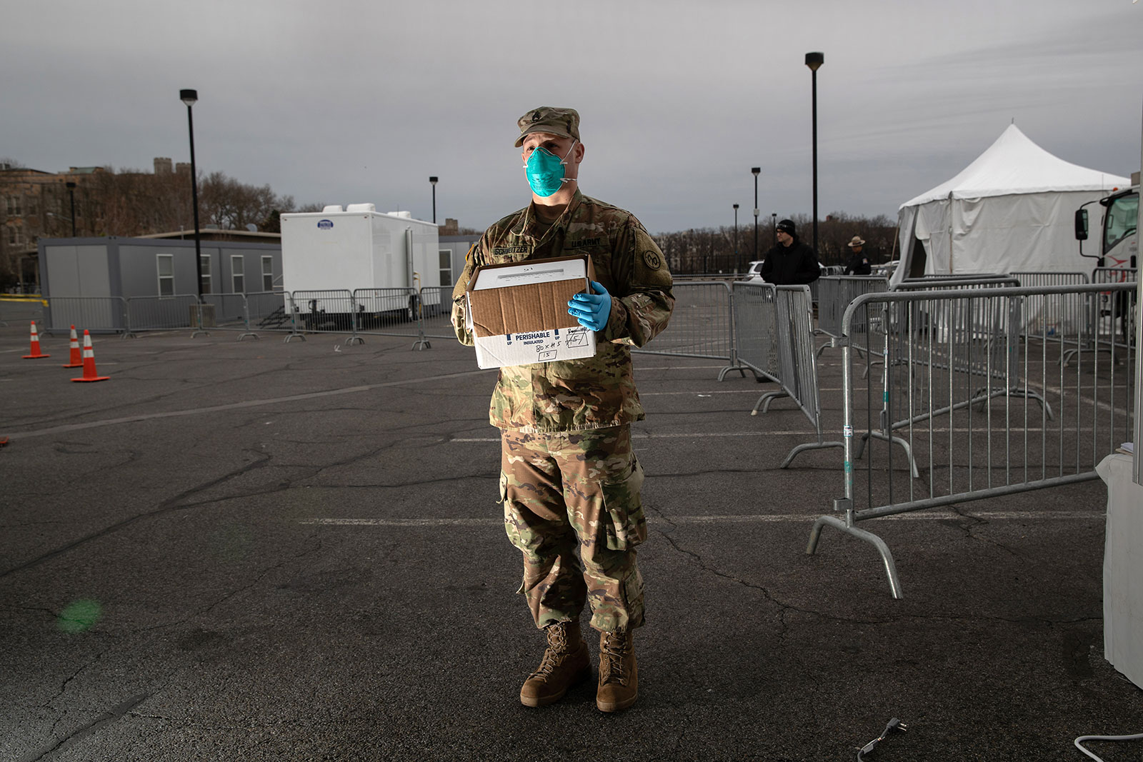 A National Guard soldier holds a case of fresh coronavirus tests at a drive-through testing center at Lehman College in New York City on March 28.