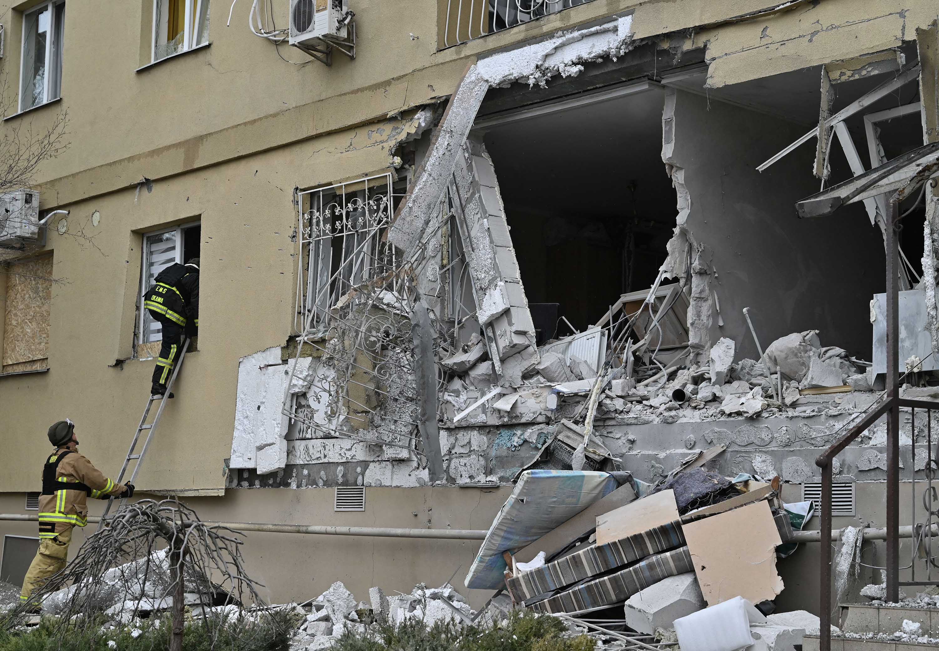 First responders inspect a damaged residential building after Russian artillery shelling in Kherson, southern Ukraine, on January 29.