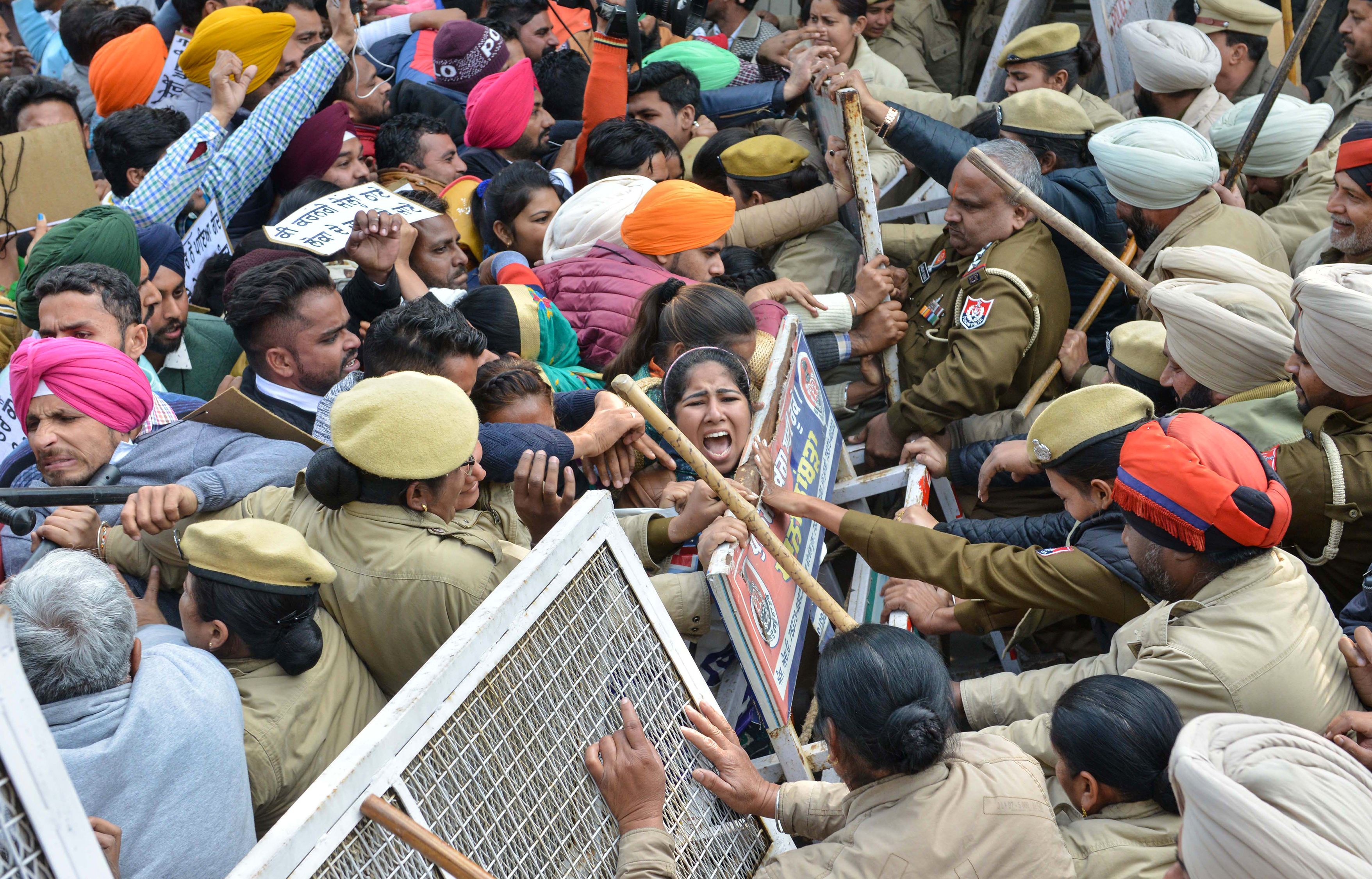  Indian police personnel block unemployed Indian teachers, as they march during a protest against the Punjab state government to demand jobs in Amritsar on January 25, 2019.