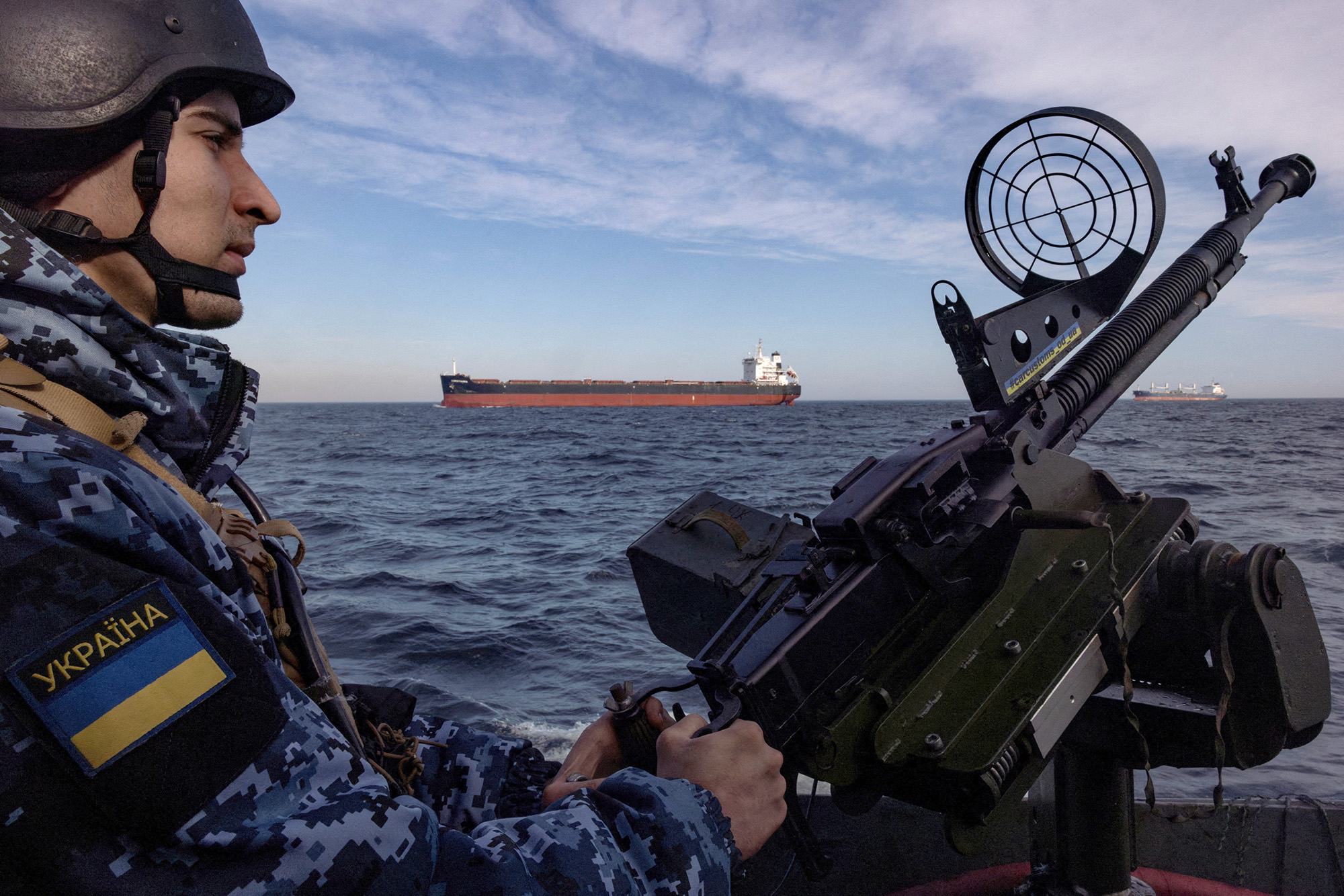 Un miembro de la guardia costera de Ucrania maneja un arma en una lancha patrullera mientras un carguero pasa por el Mar Negro el 7 de febrero.