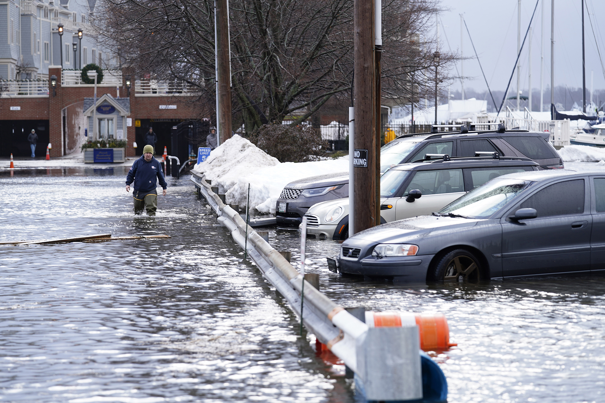 A man wades through a flooded parking lot near Widgery Wharf on January 10, in Portland, Maine.