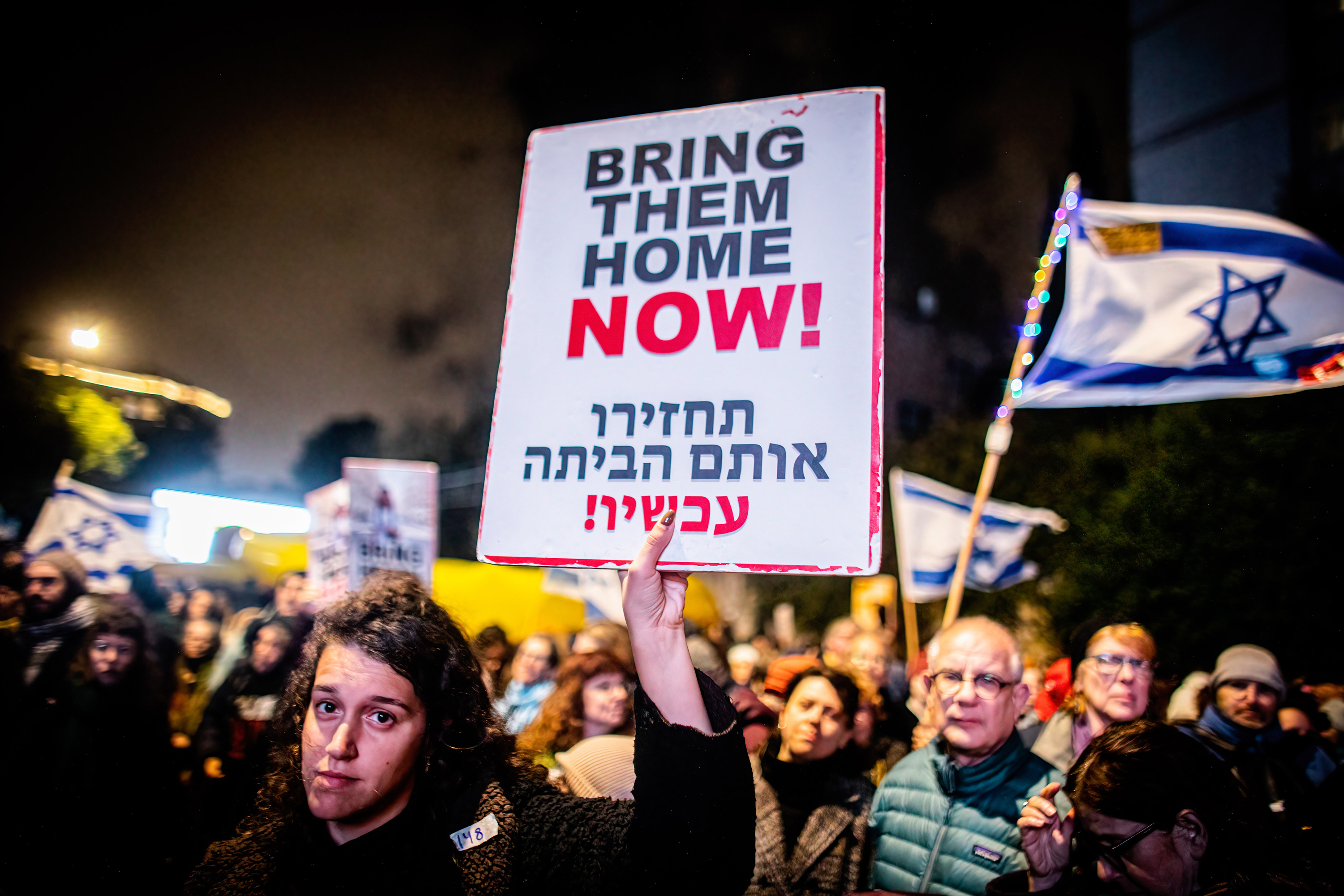 A protester holds a placard that says "Bring them home now!" during a demonstration march on March 2, in Jerusalem, Israel, demanding the release of hostages taken on October 7 by Hamas.