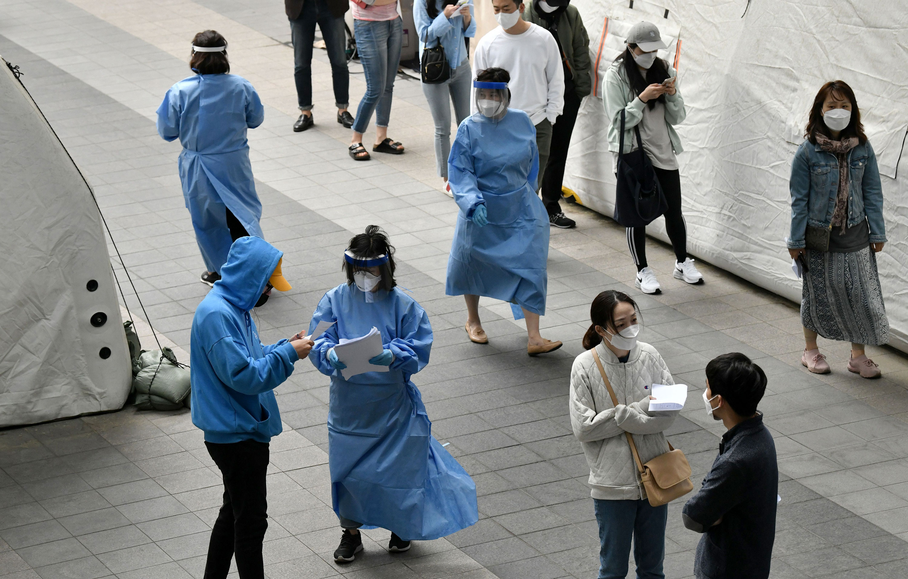 Medical staff guide visitors waiting to be tested for coronavirus at a testing site in the nightlife district of Itaewon in Seoul, South Korea, on May 12.