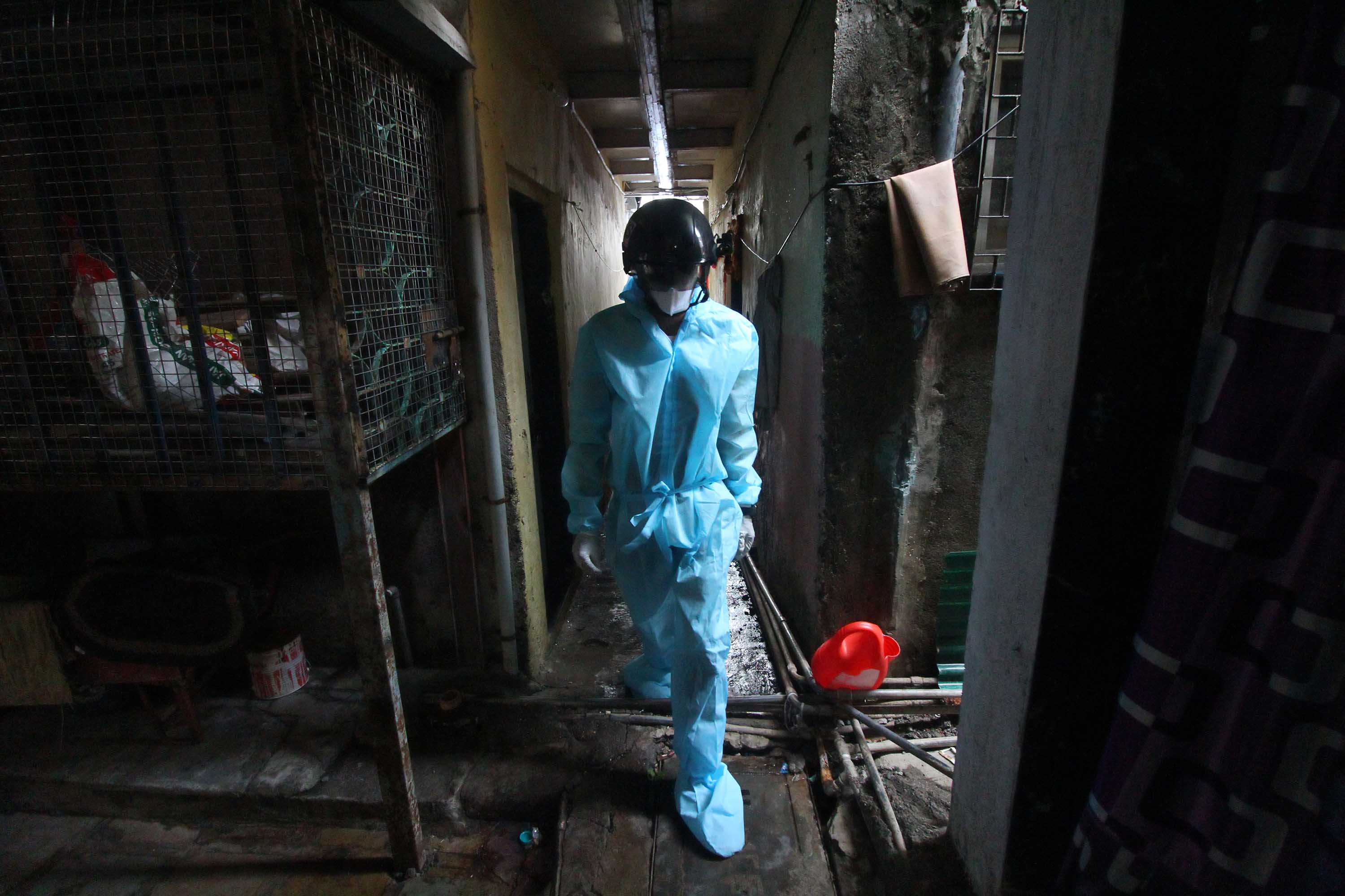 A health care worker walks through an alley of a Mumbai slum during a medical check-up on July 20.