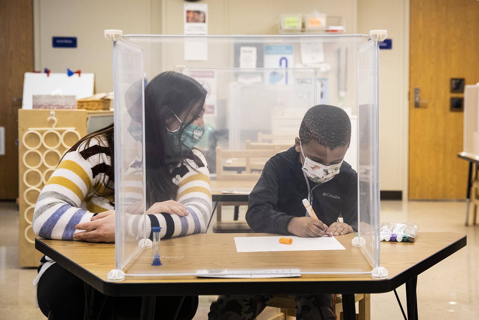 Pre-kindergarten teacher Sarah McCarthy works with a student at Dawes Elementary in Chicago on Monday, January 11.