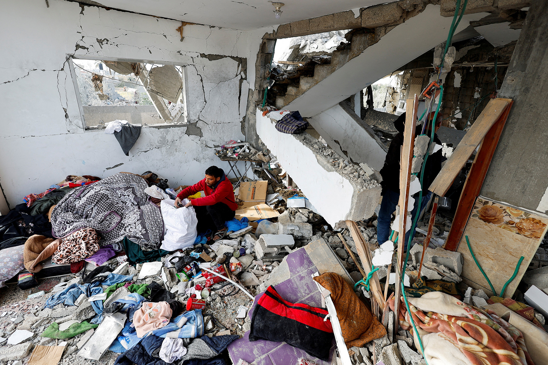 A Palestinian man retrieves belongings from the site of Israeli strikes on a house, in Rafah, Gaza, on March 26. 