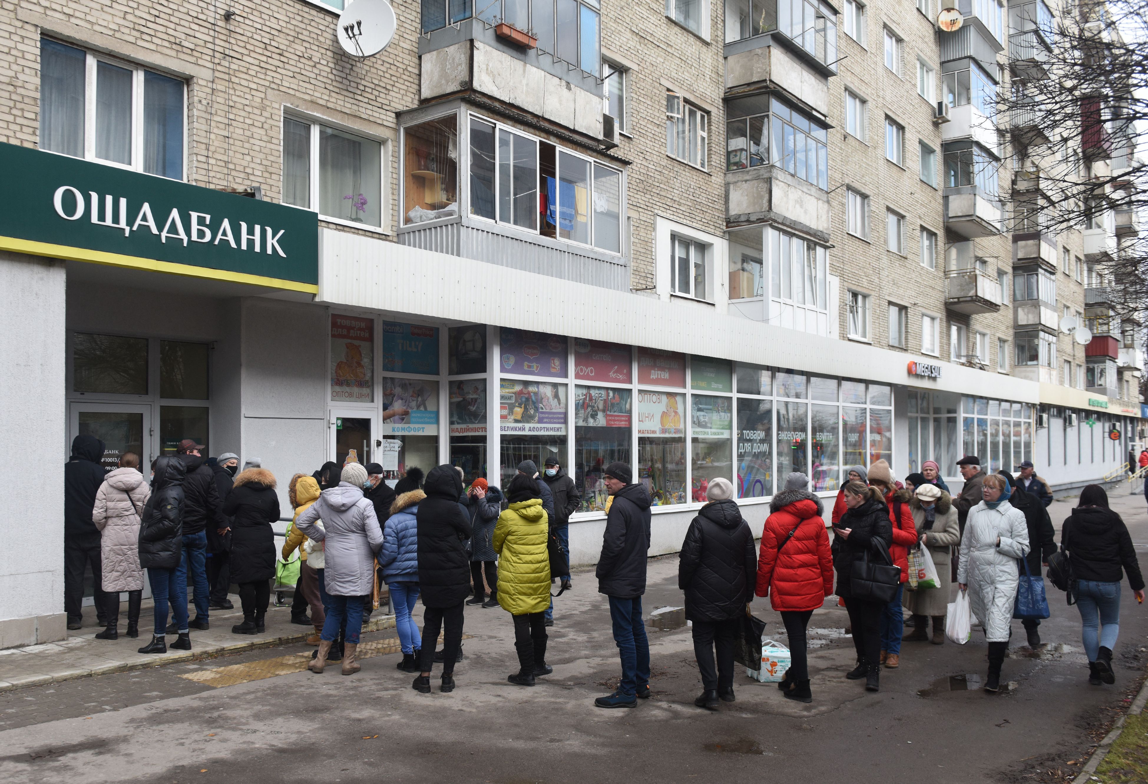 People line up to withdraw money at cash machines in the western Ukrainian city of Lviv on February 24.