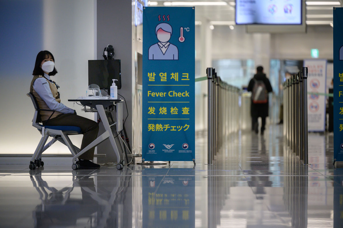 A health worker waits to screen passengers at Incheon International Airport in South Korea on December 29.