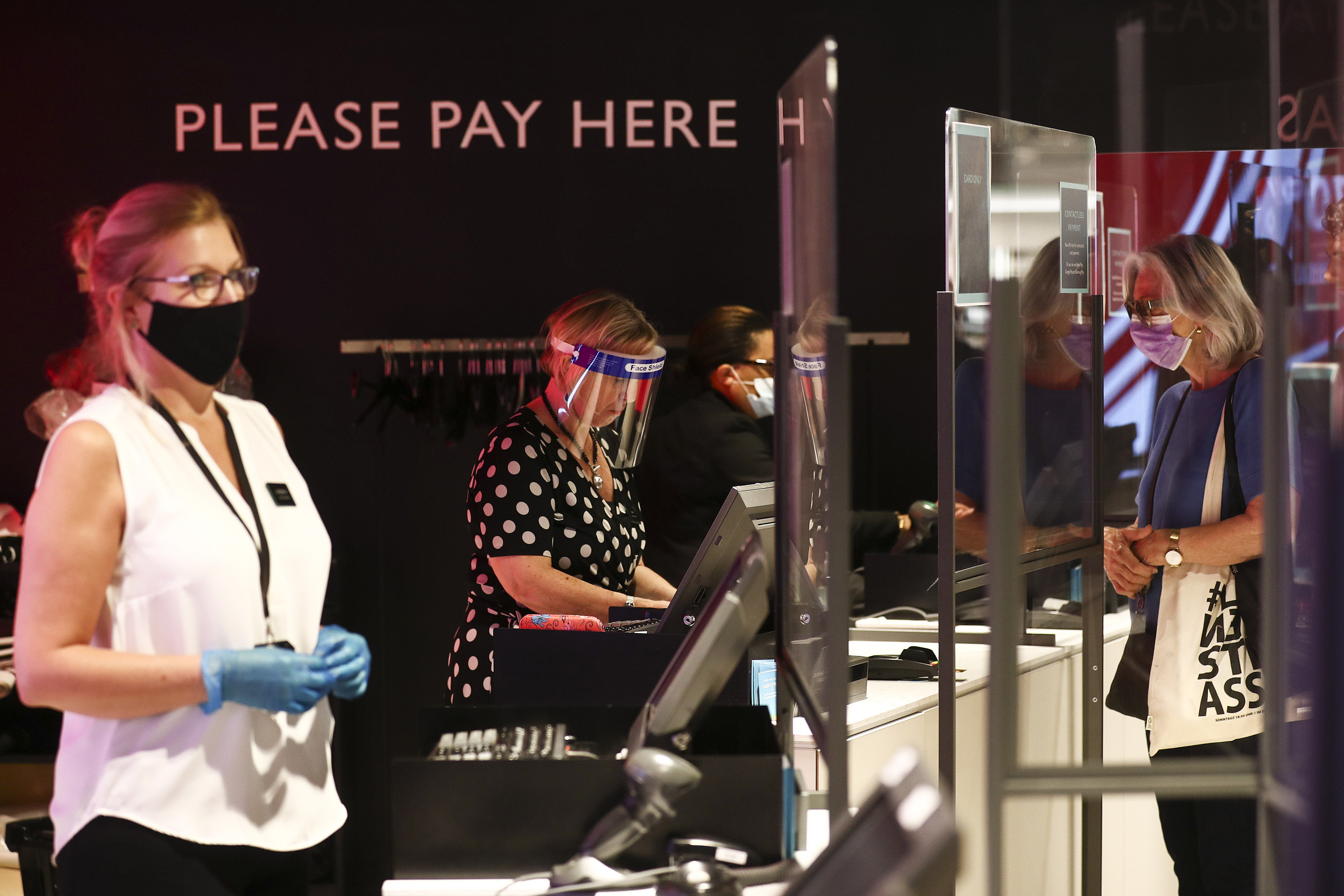Employees serve customers on July 23 inside a John Lewis Partnership department store in London.