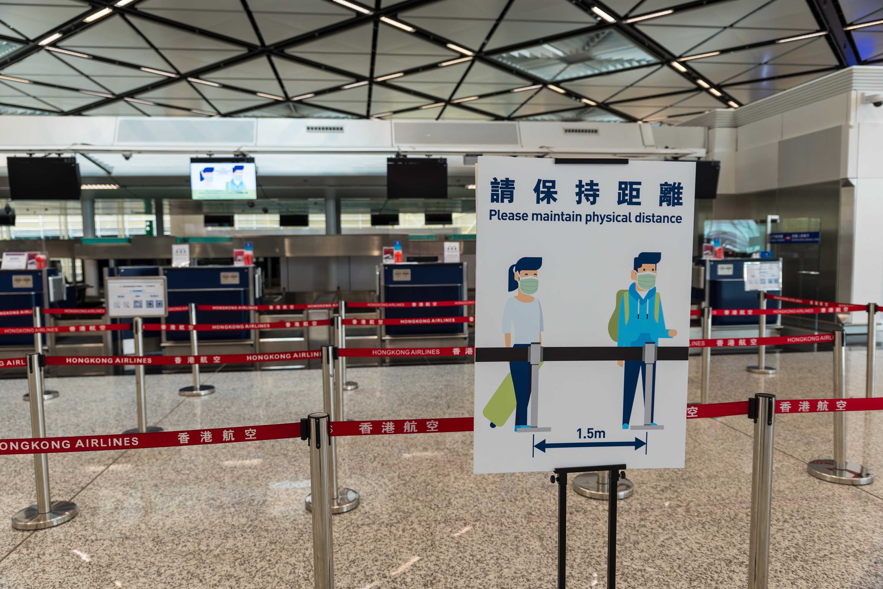 Social distancing guidance is posted on a sign in the check-in area at Hong Kong International Airport on September 4.